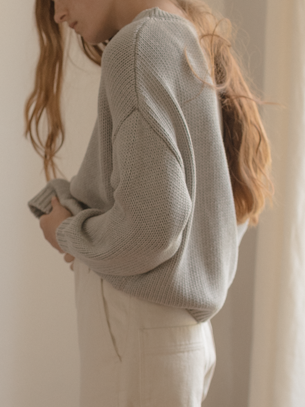 Model wearing the Townes Pullover in Pebble by Gillian Stevens, side view showing sleeve detail