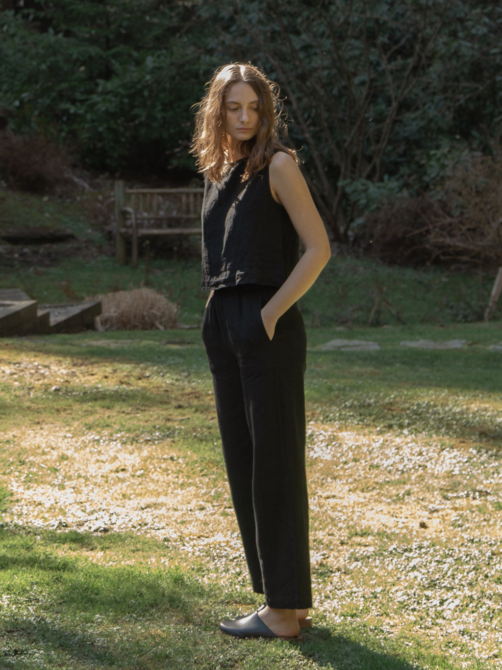 Model wearing the Finley Top in Noir by Gillian Stevens, full-length front view in a garden setting