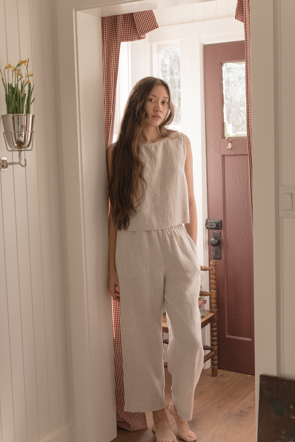 Model wearing the Finley Pant in Oatmeal by Gillian Stevens, full-length front view in a cottage hallway