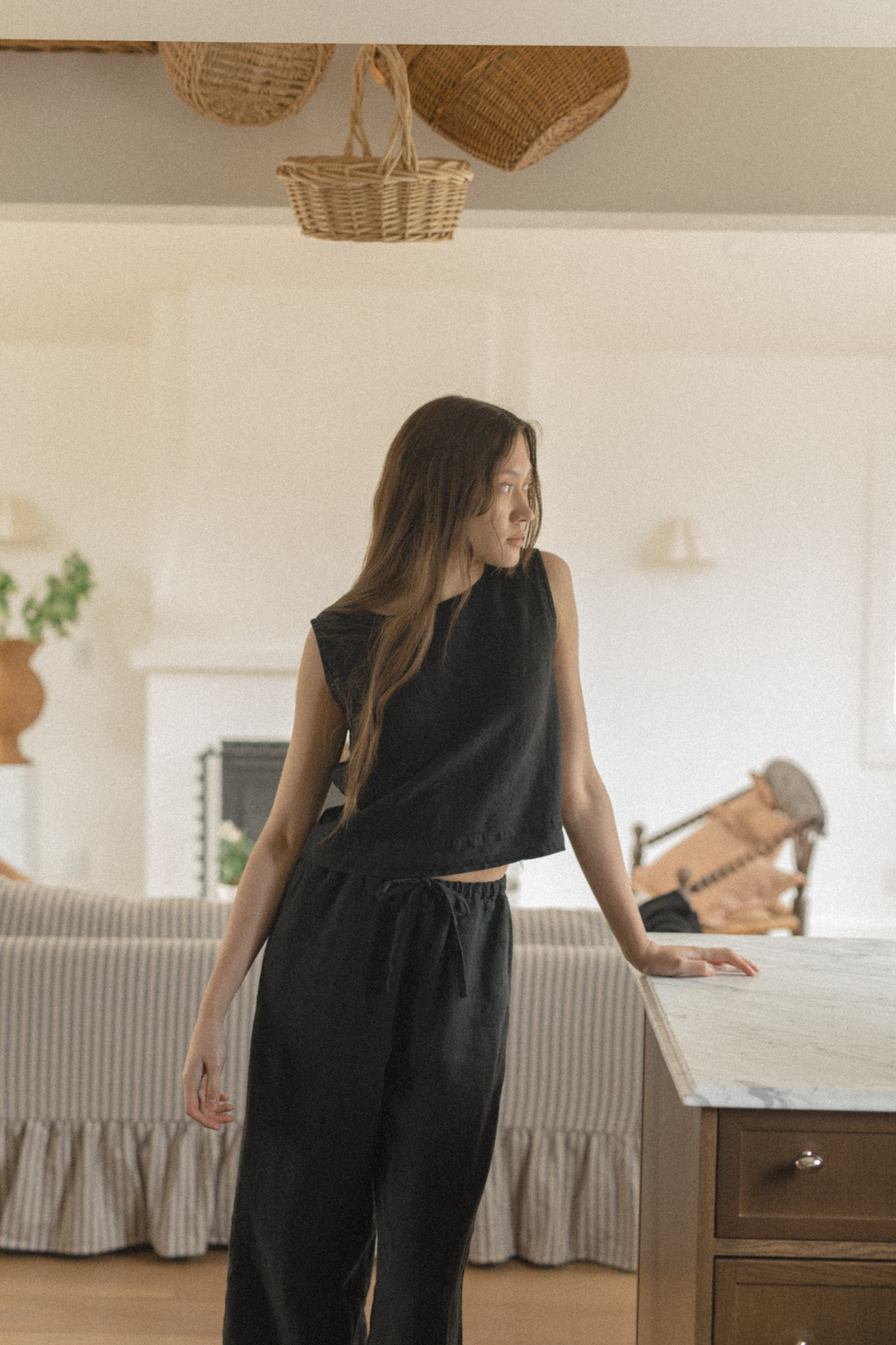 Model wearing the Finley Top in Noir by Gillian Stevens, front view in a warm home interior