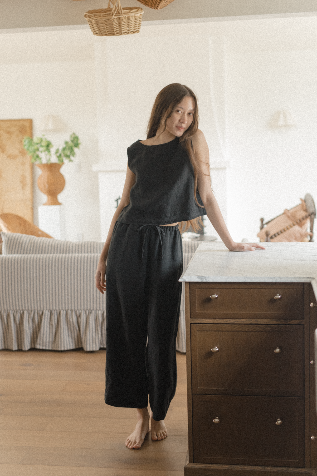 Model wearing the Finley Top in Noir by Gillian Stevens, front view in a styled home interior setting