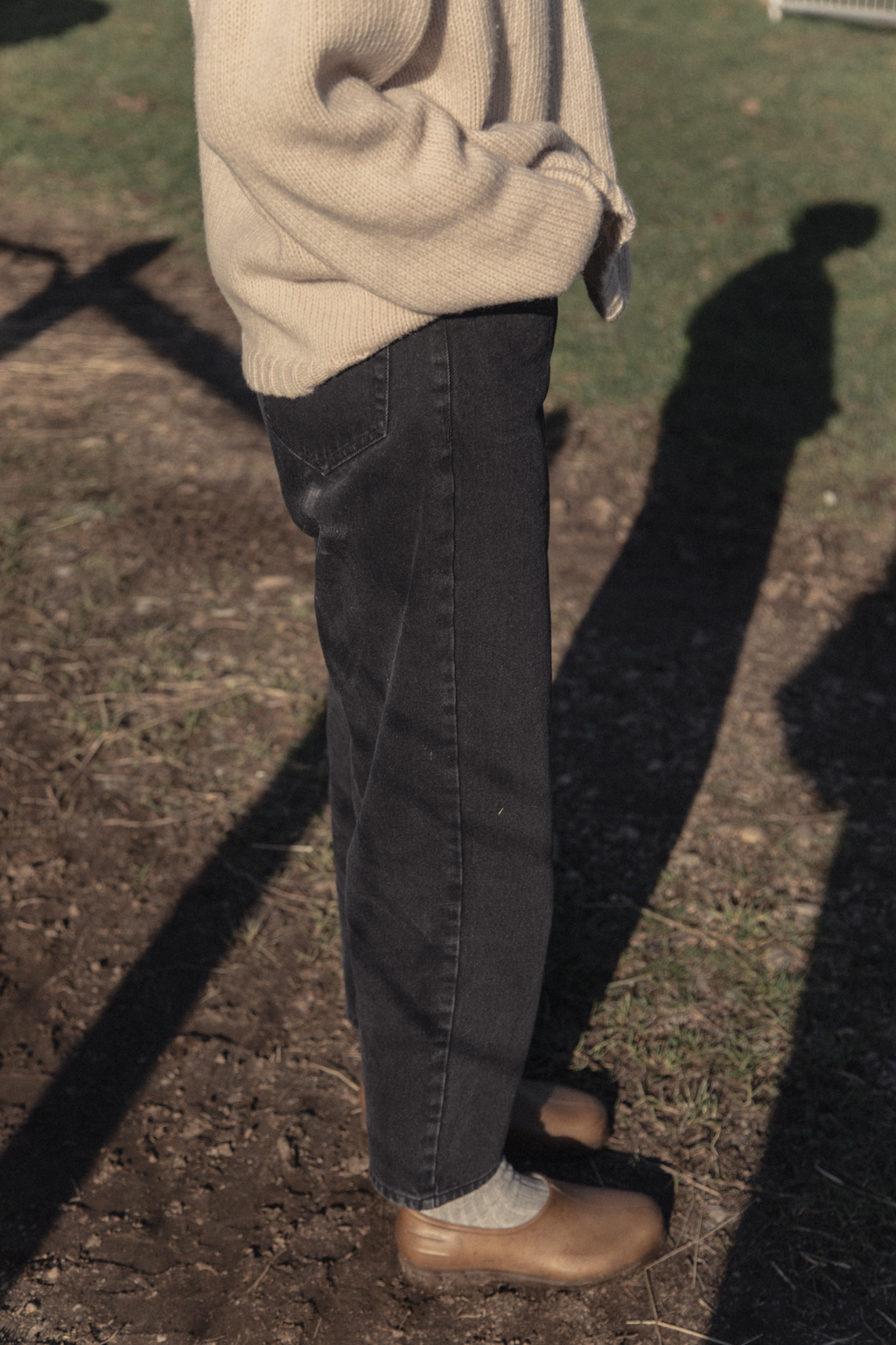 Model wearing the Dara Jean in Noir by Gillian Stevens, side view showing relaxed leg and hem