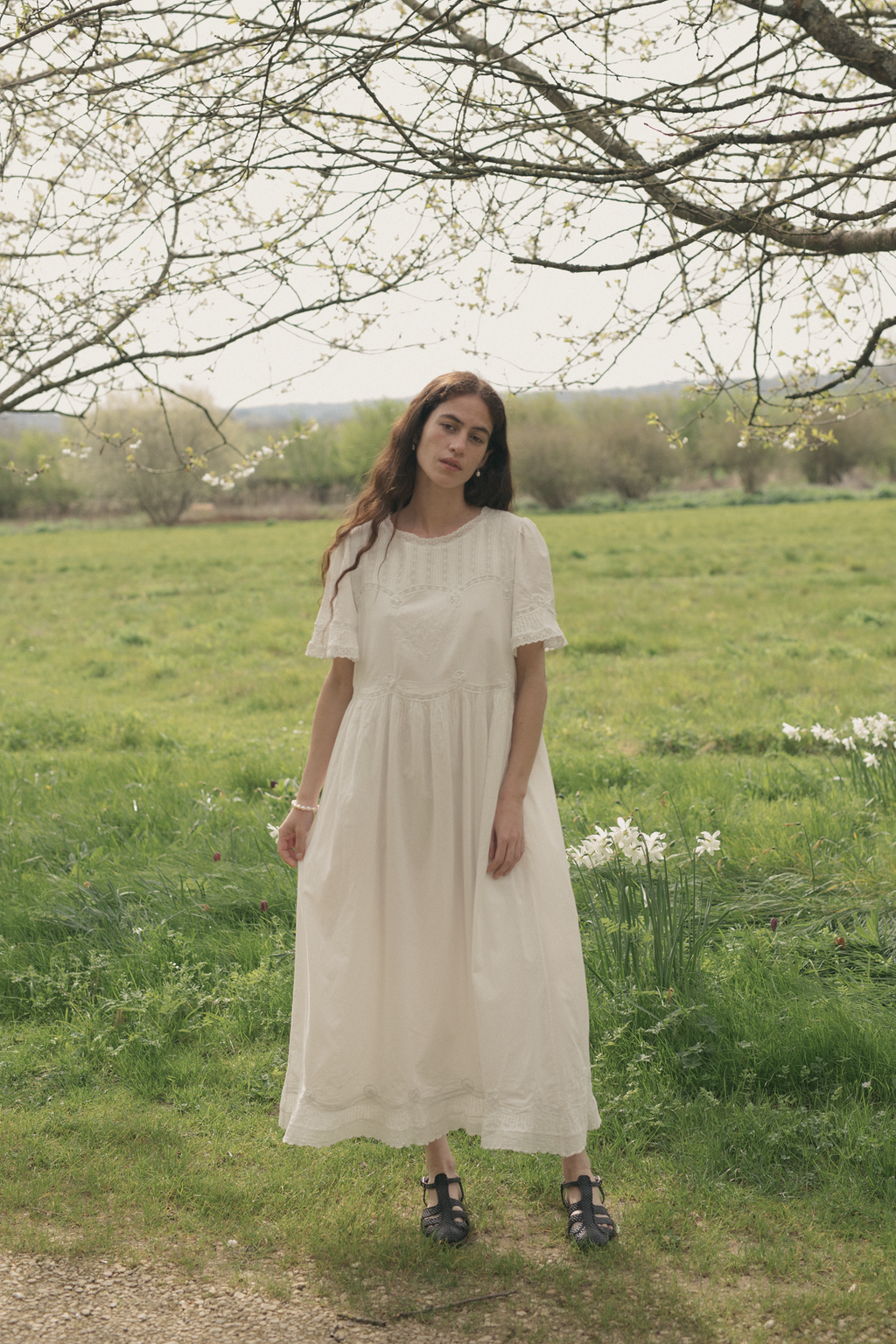 Model wearing the Astrid Dress in Salt by Gillian Stevens, full-length front view in a spring meadow