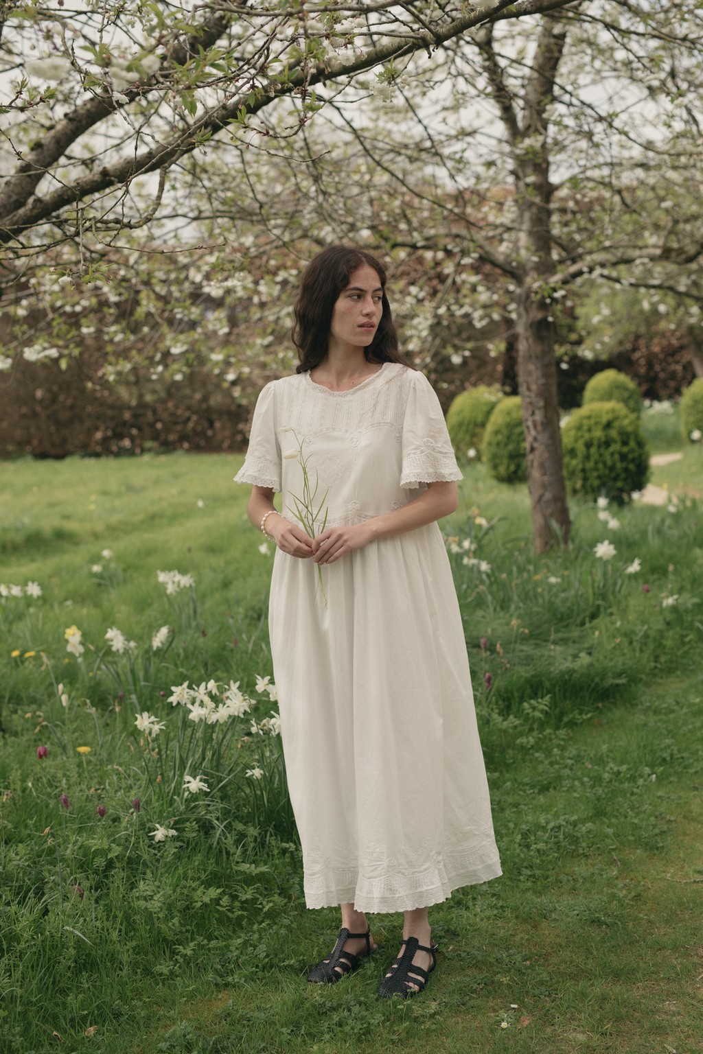 Model wearing the Astrid Dress in Salt by Gillian Stevens, full-length front view in a garden setting