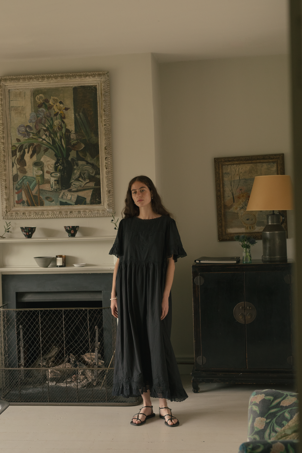 Model wearing the Astrid Dress in Noir by Gillian Stevens, full-length front view in styled interior