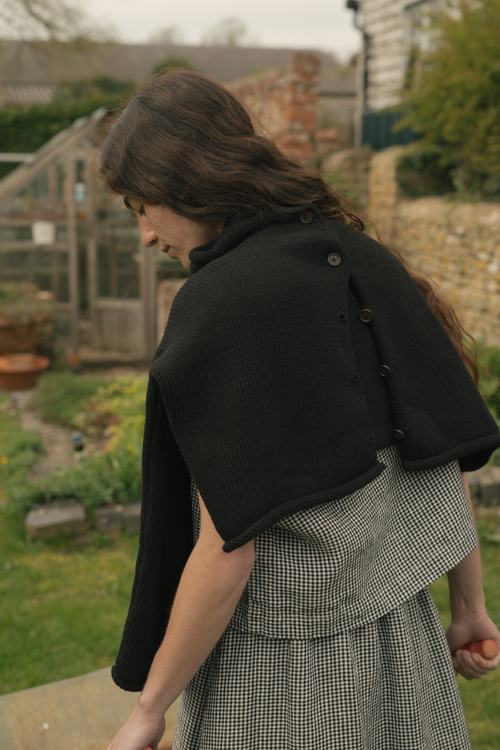 Model wearing the Lennon Cardigan in Noir by Gillian Stevens, back view showing button placket detail