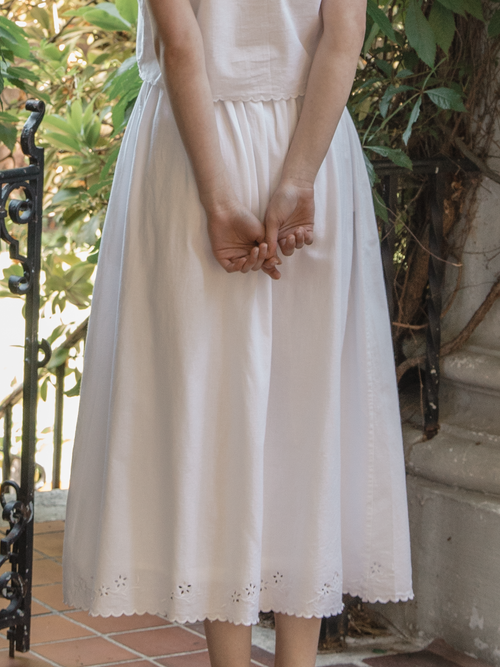 Model wearing the Aurelie Skirt in Salt by Gillian Stevens, back view showing eyelet hem detail