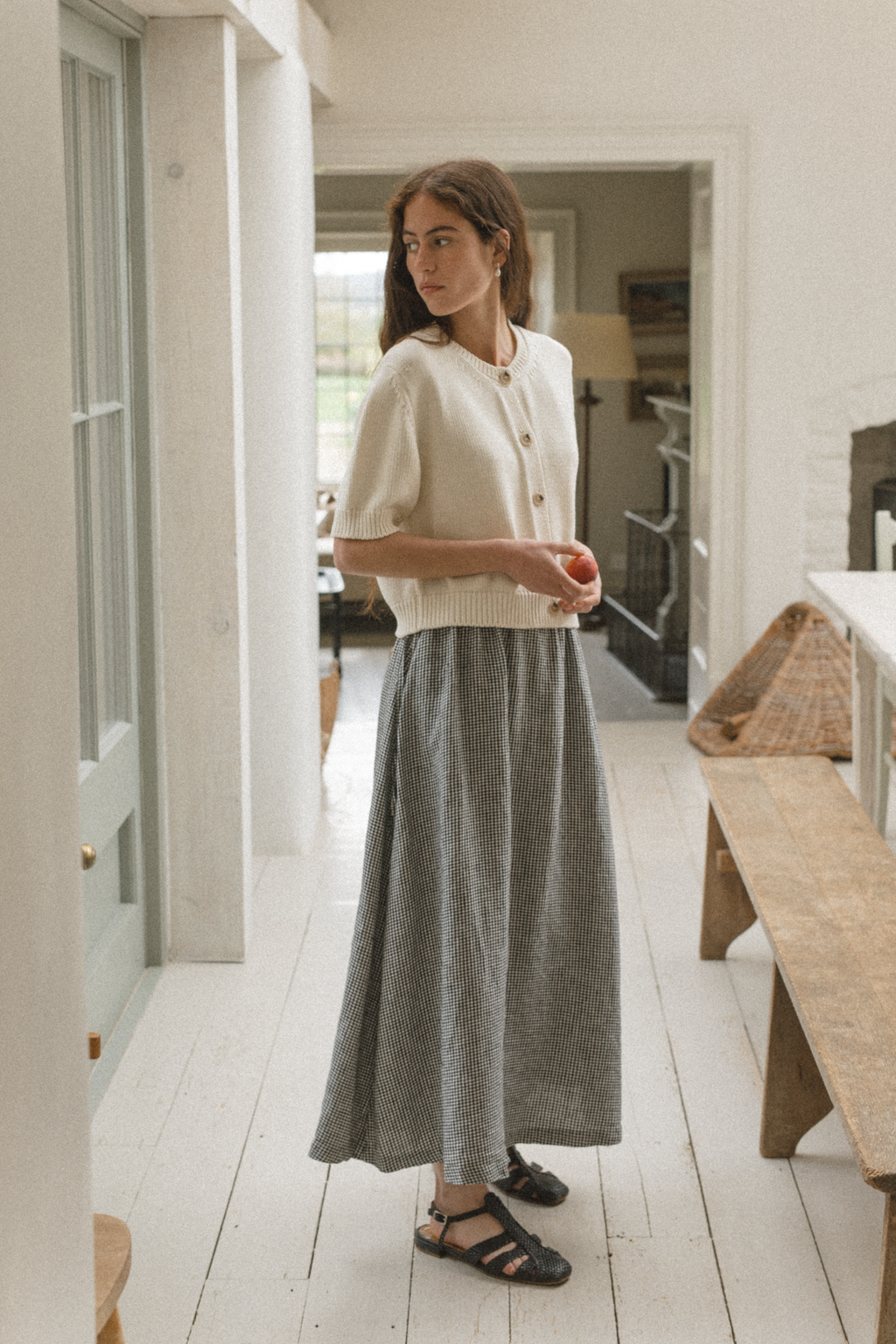 Model wearing the Frances Skirt in Gingham Noir by Gillian Stevens, three-quarter view in a hallway setting