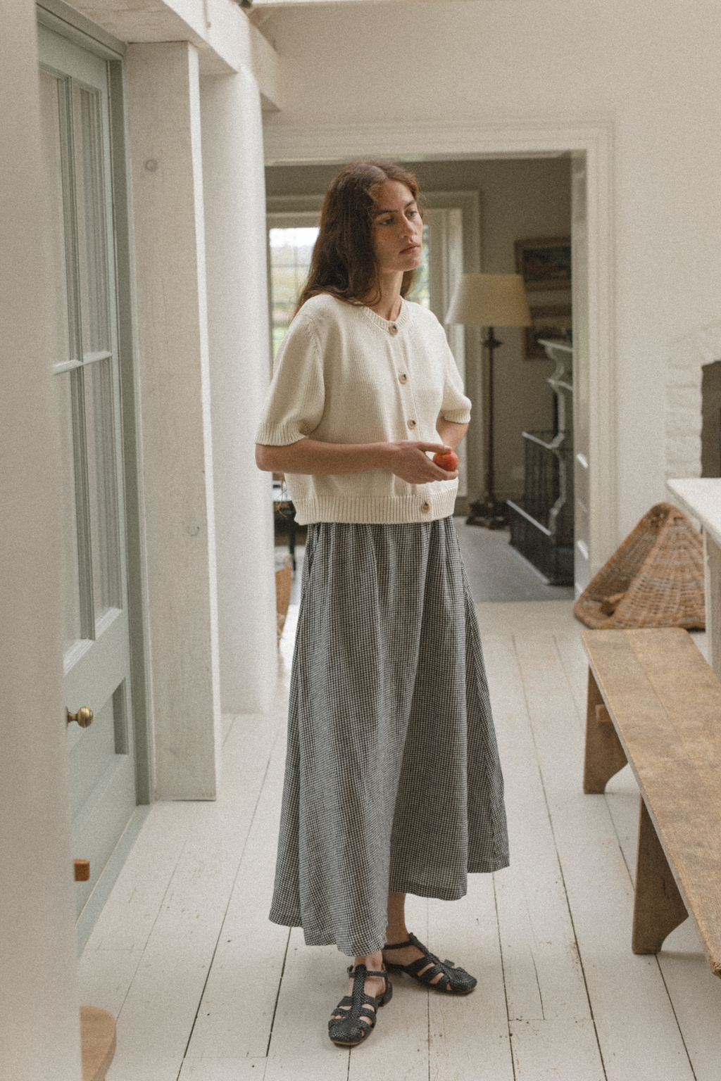 Model wearing the Frances Skirt in Gingham Noir by Gillian Stevens, full-length front view in a hallway setting