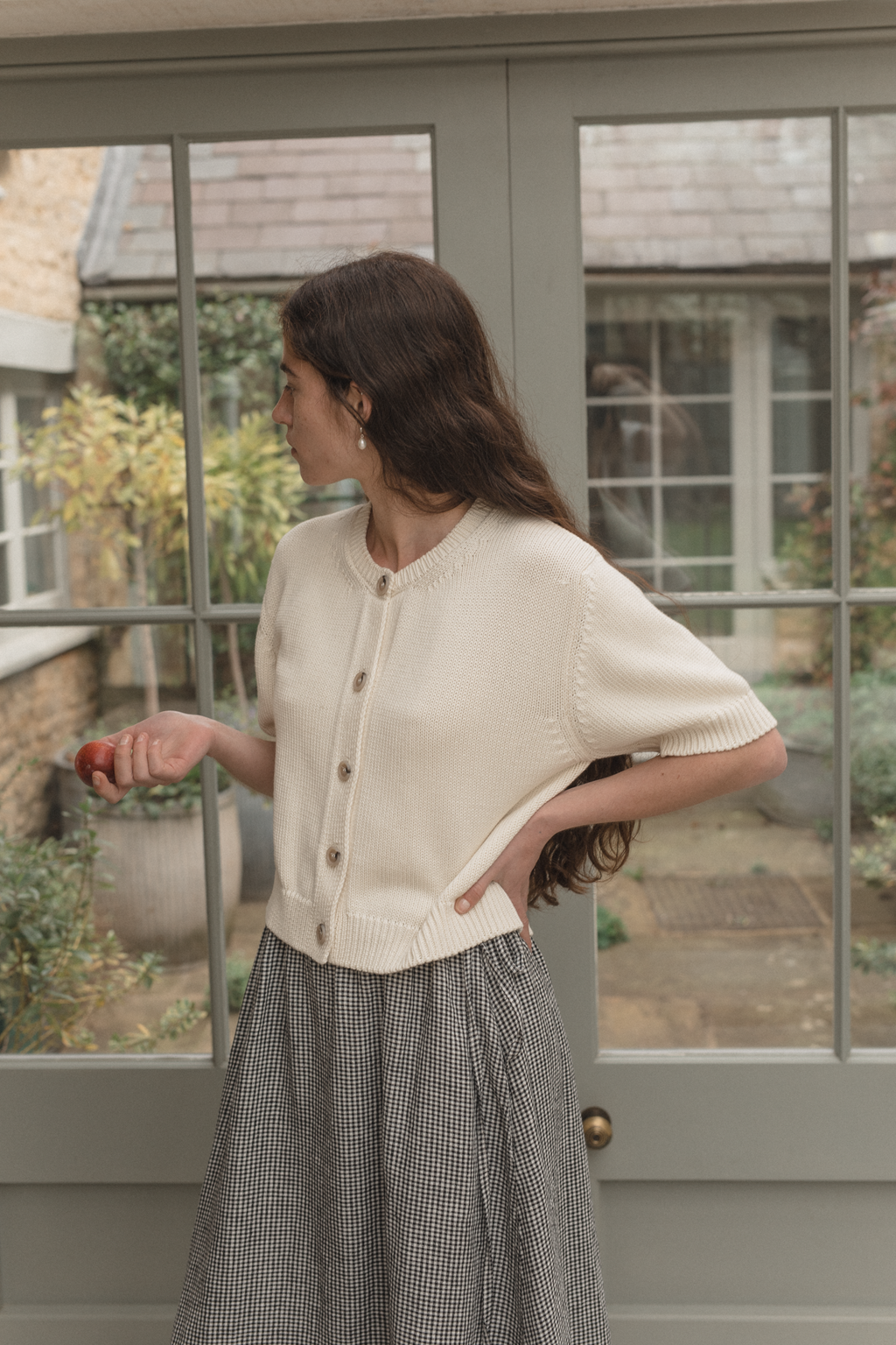 Model wearing the Rosemary Cardigan in Alabaster by Gillian Stevens, side view showing button front and short sleeves