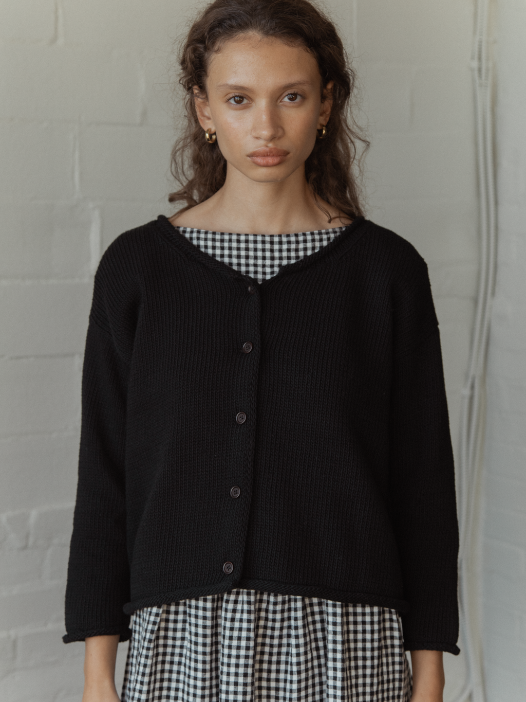 Model wearing the Lennon Cardigan in Noir by Gillian Stevens, front view showing button detail