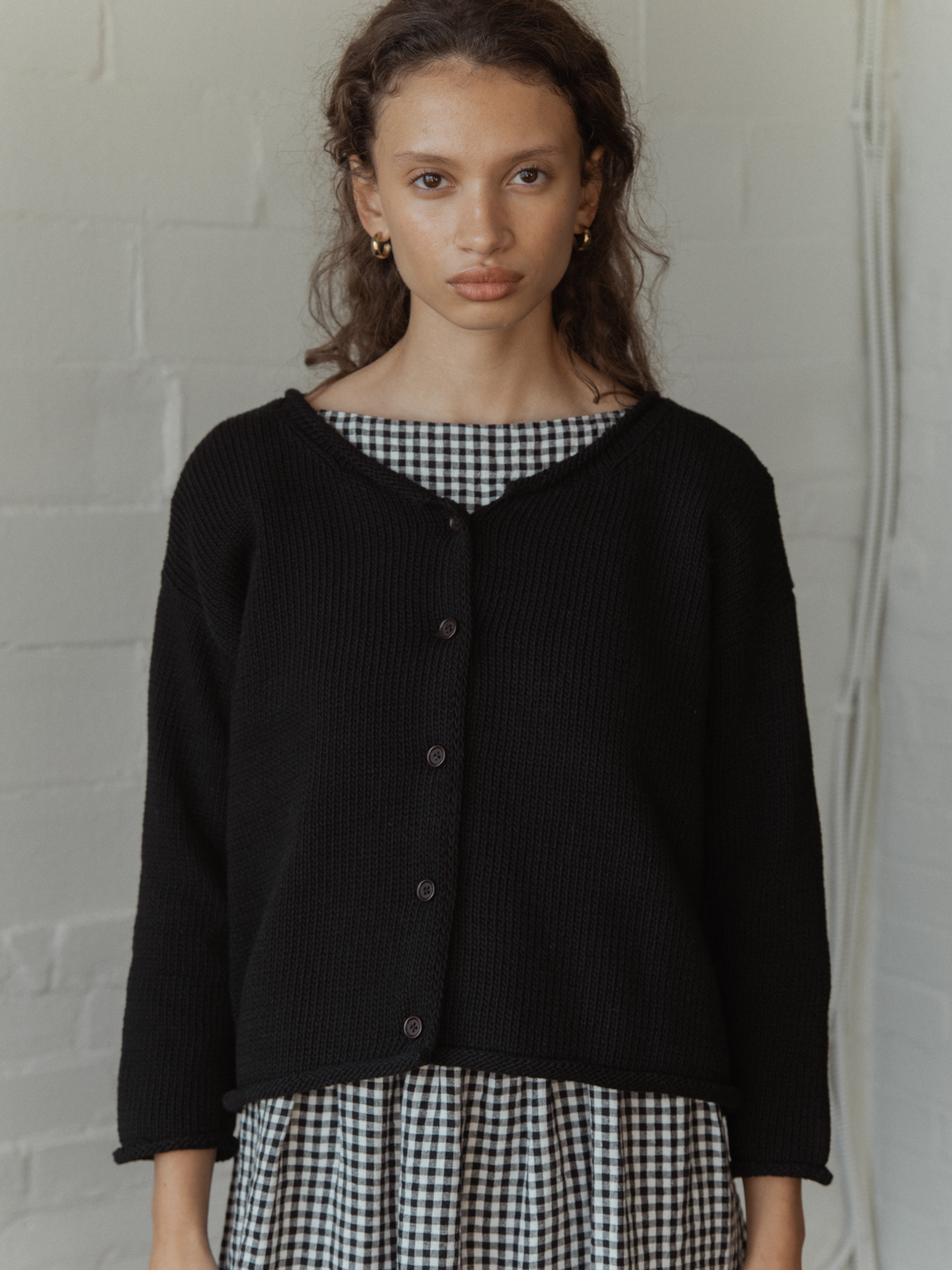 Model wearing the Lennon Cardigan in Noir by Gillian Stevens, front view showing button detail