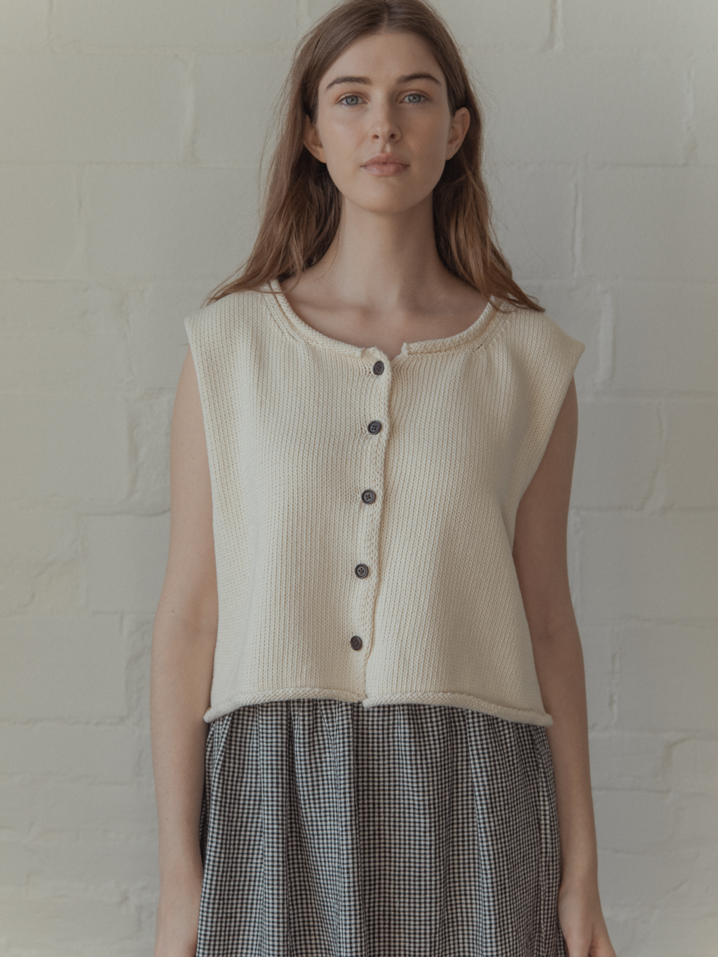 Model wearing the Lennon Vest in Ivory by Gillian Stevens, front view showing button detail, view 2