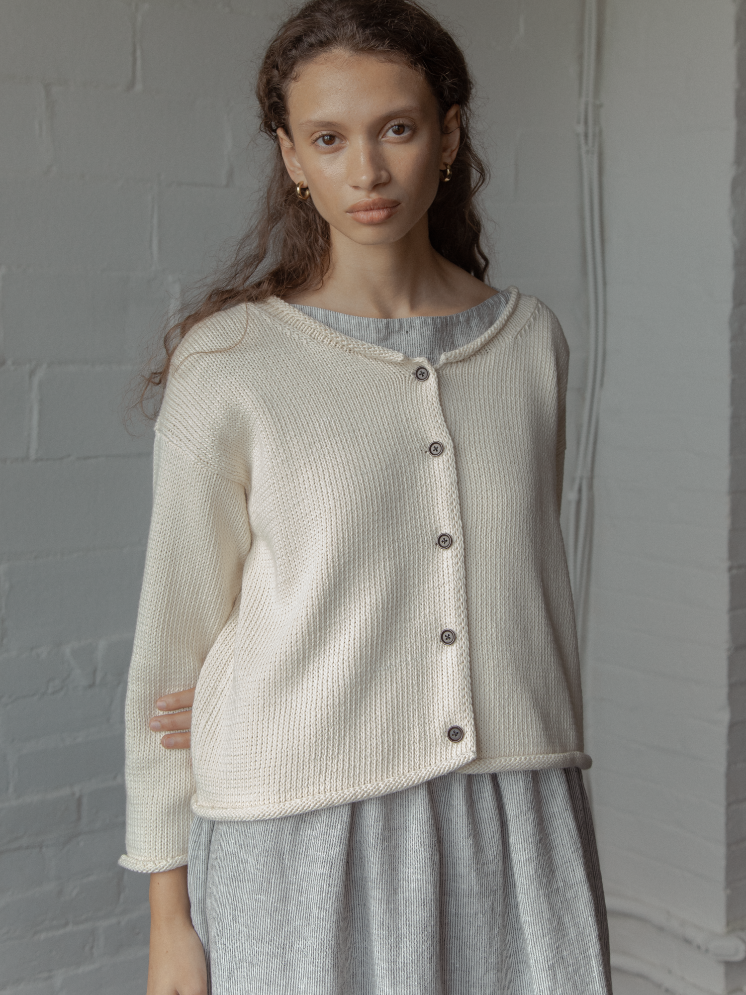 Model wearing the Lennon Cardigan in Ivory by Gillian Stevens, front view showing dark button detail, view 2
