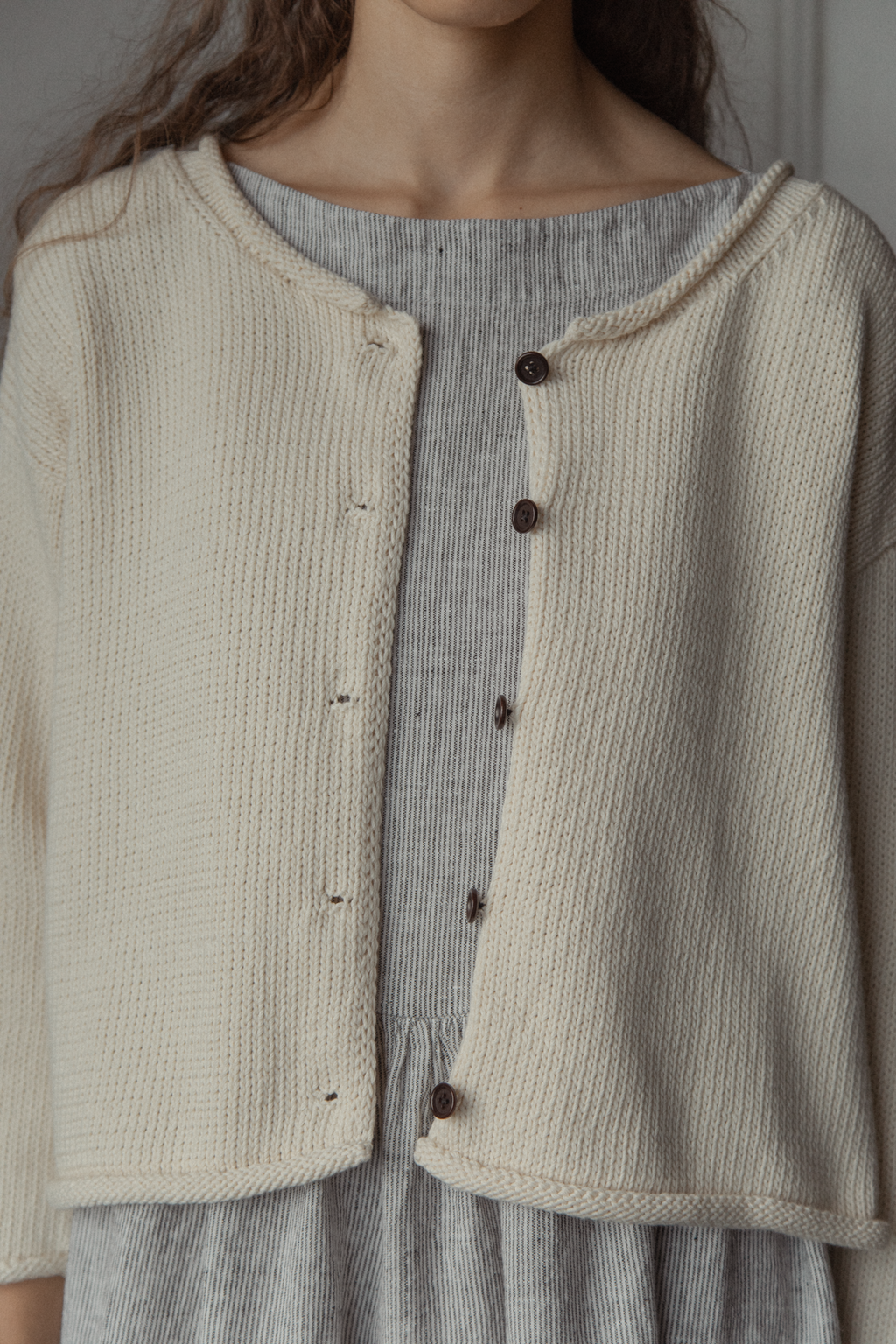 Close-up of the Lennon Cardigan in Ivory by Gillian Stevens, showing button and knit texture detail