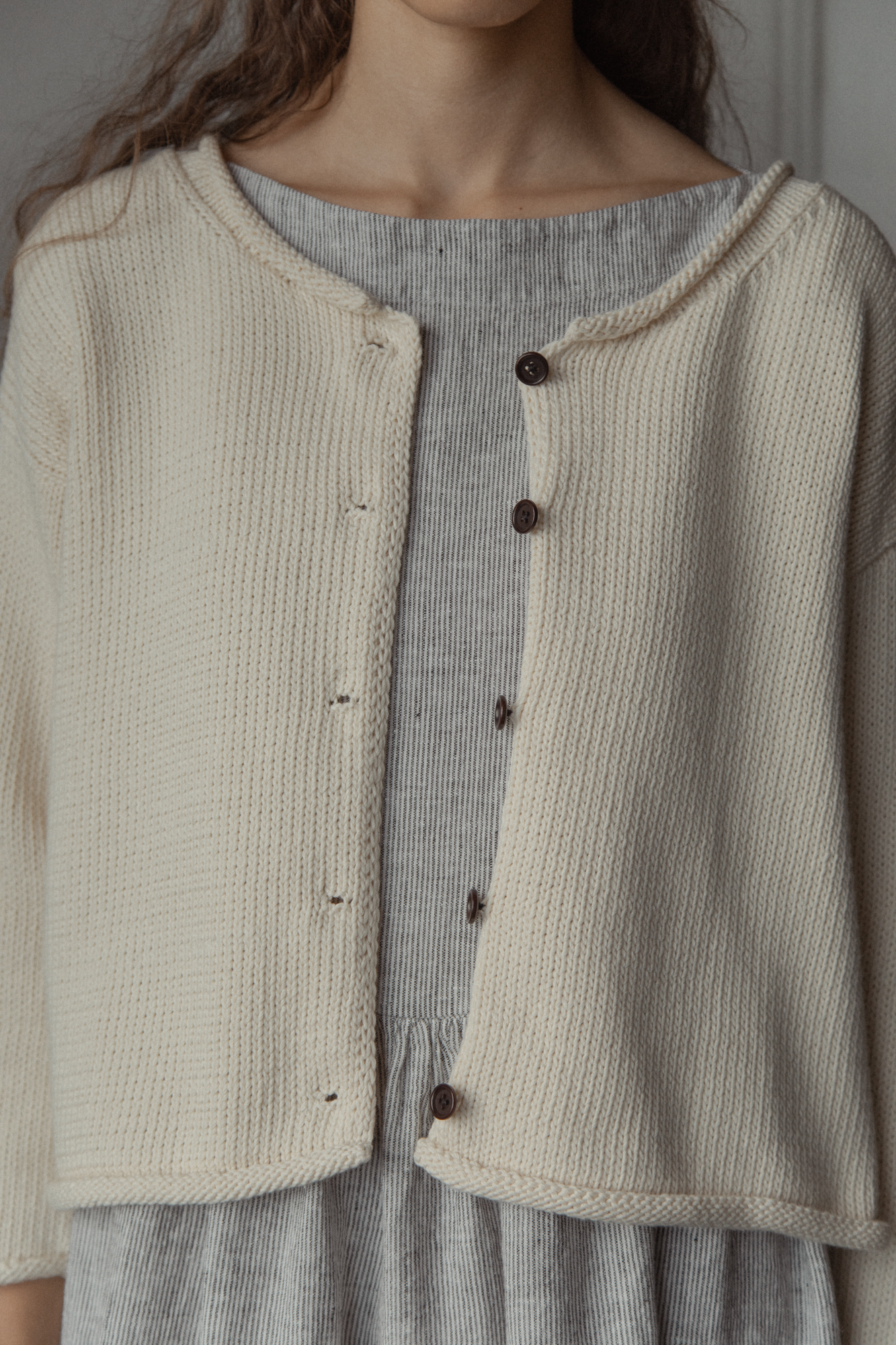 Close-up of the Lennon Cardigan in Ivory by Gillian Stevens, showing button and knit texture detail