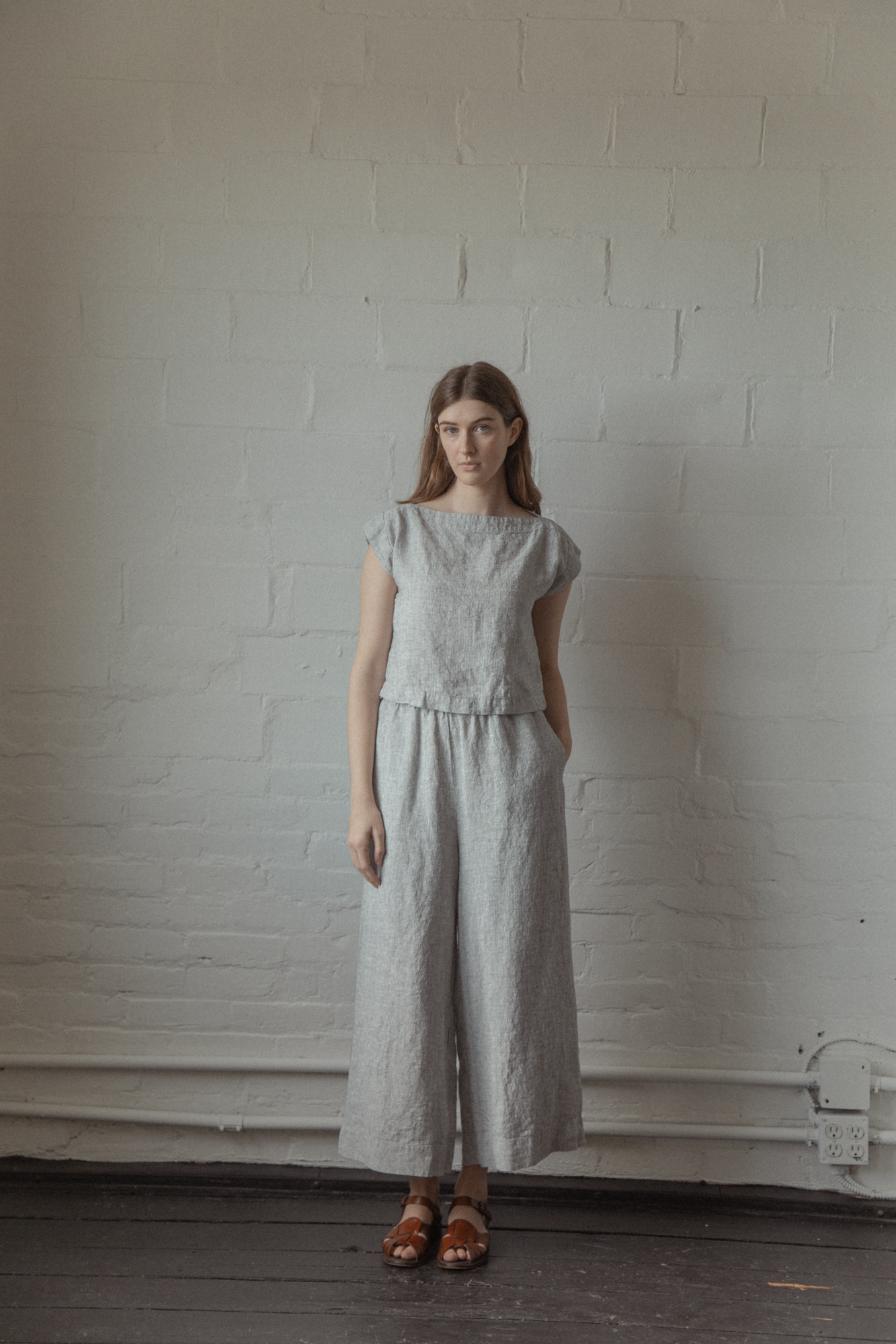 Model wearing the Ines Pant in Charcoal Stripe by Gillian Stevens, front view showing wide leg and linen texture