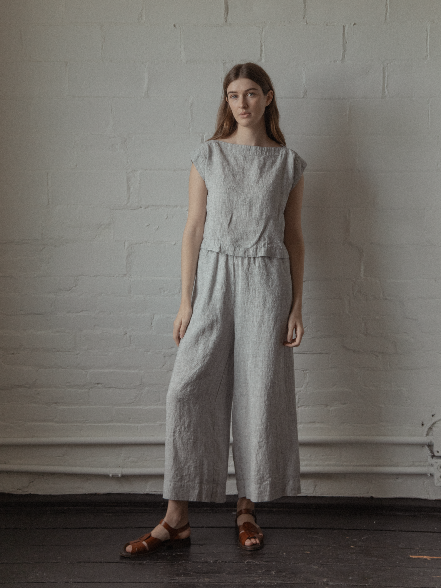 Model wearing the Valley Top in Charcoal Stripe by Gillian Stevens, full-length front view styled with wide-leg linen pants