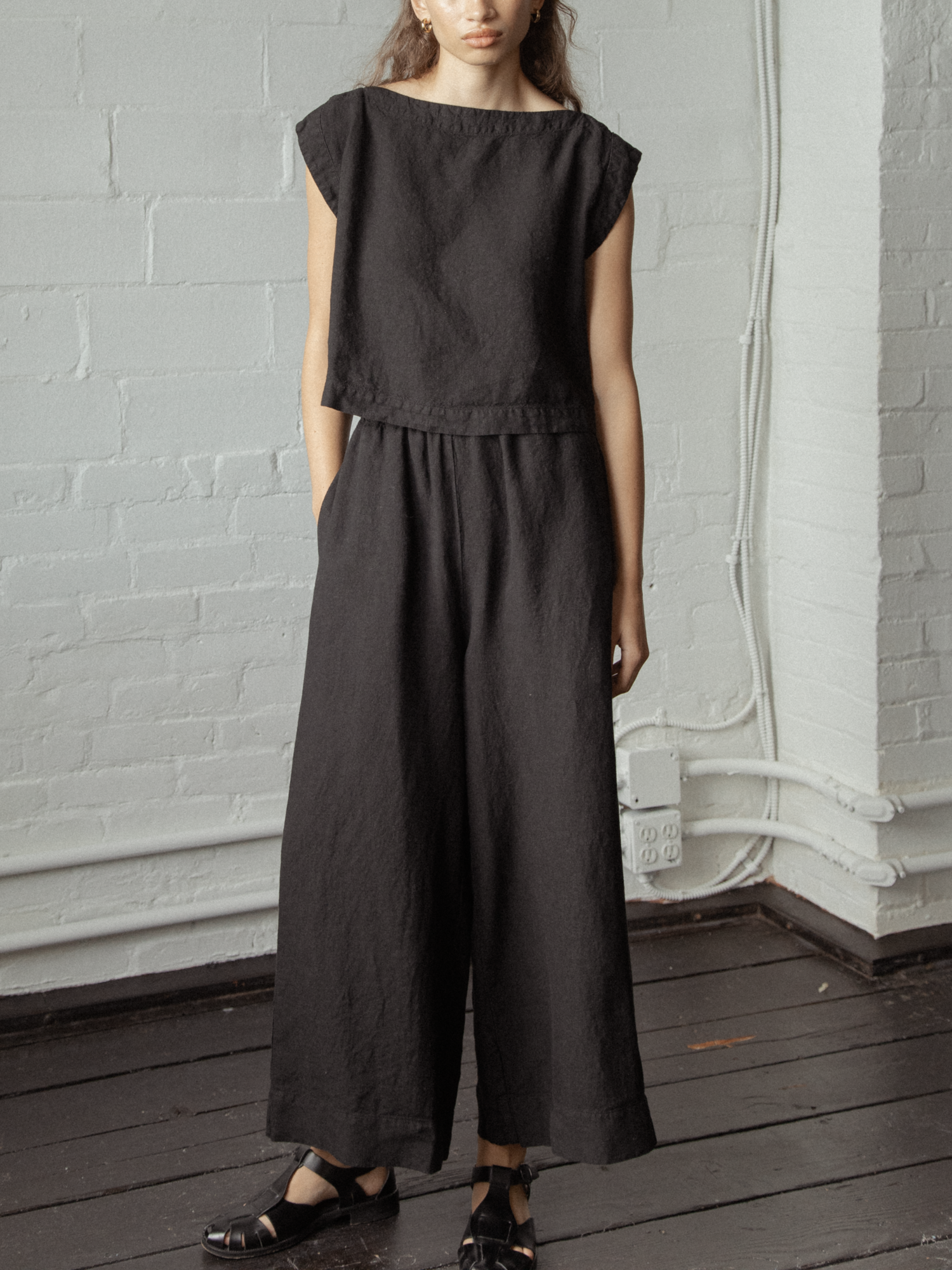 Model wearing the Valley Top in Noir by Gillian Stevens, front view styled with wide-leg linen trousers