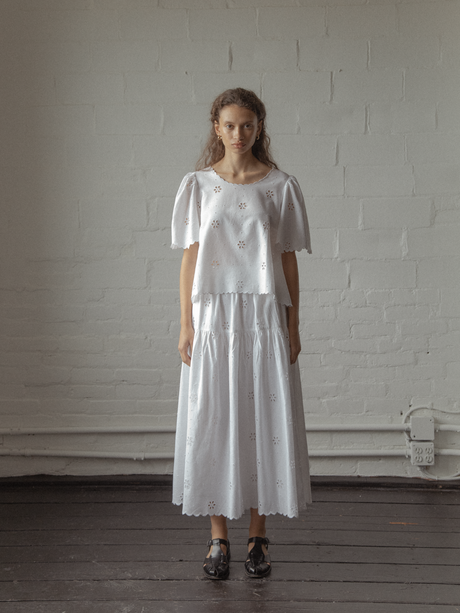 Model wearing the Stella Skirt in Salt by Gillian Stevens, styled with matching broderie top, front view