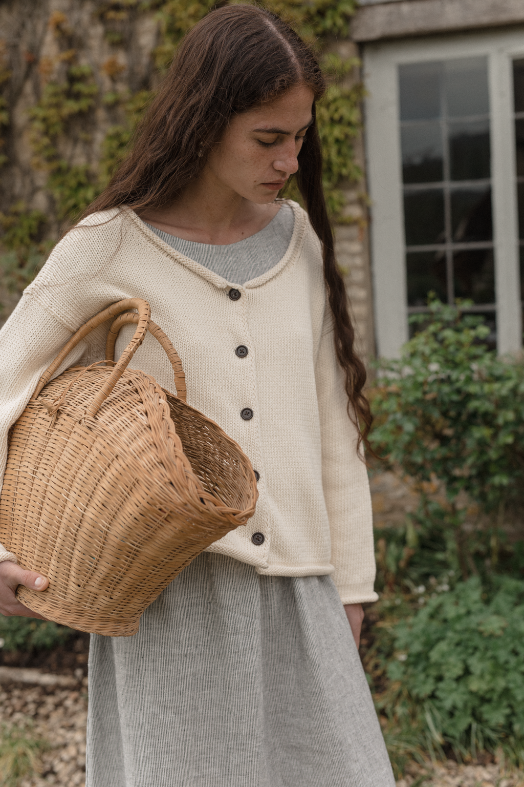 Model wearing the Lennon Cardigan in Ivory by Gillian Stevens, front view showing dark button detail