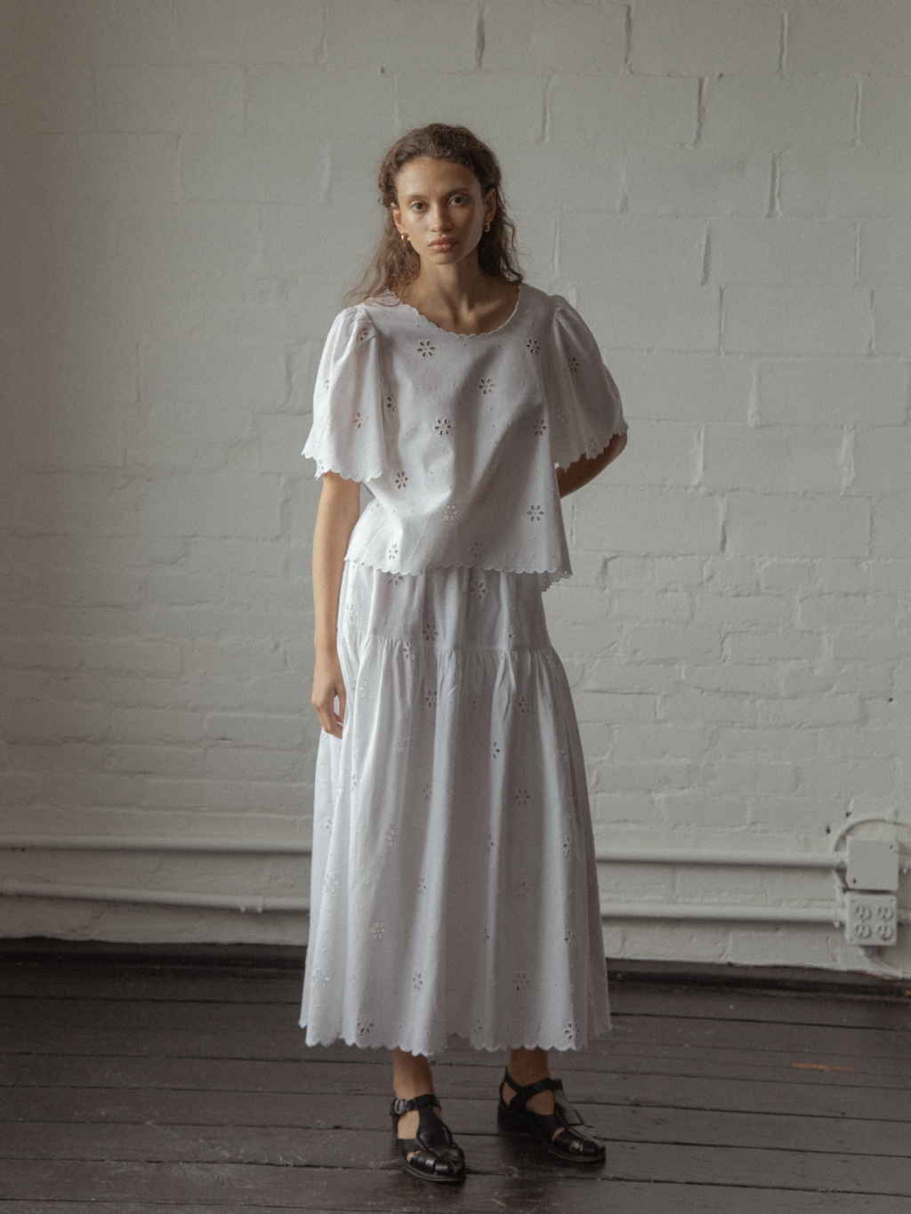 Model wearing the Stella Skirt in Salt by Gillian Stevens, styled with matching eyelet top, front view