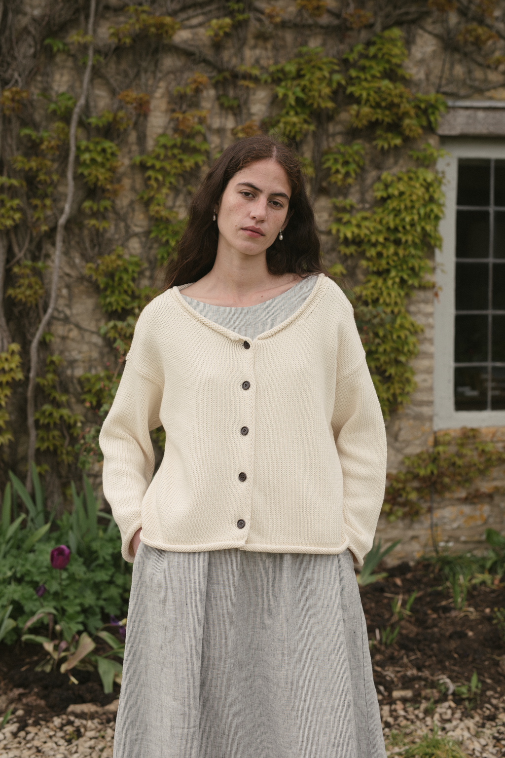 Model wearing the Lennon Cardigan in Ivory by Gillian Stevens, front view showing button detail outdoors