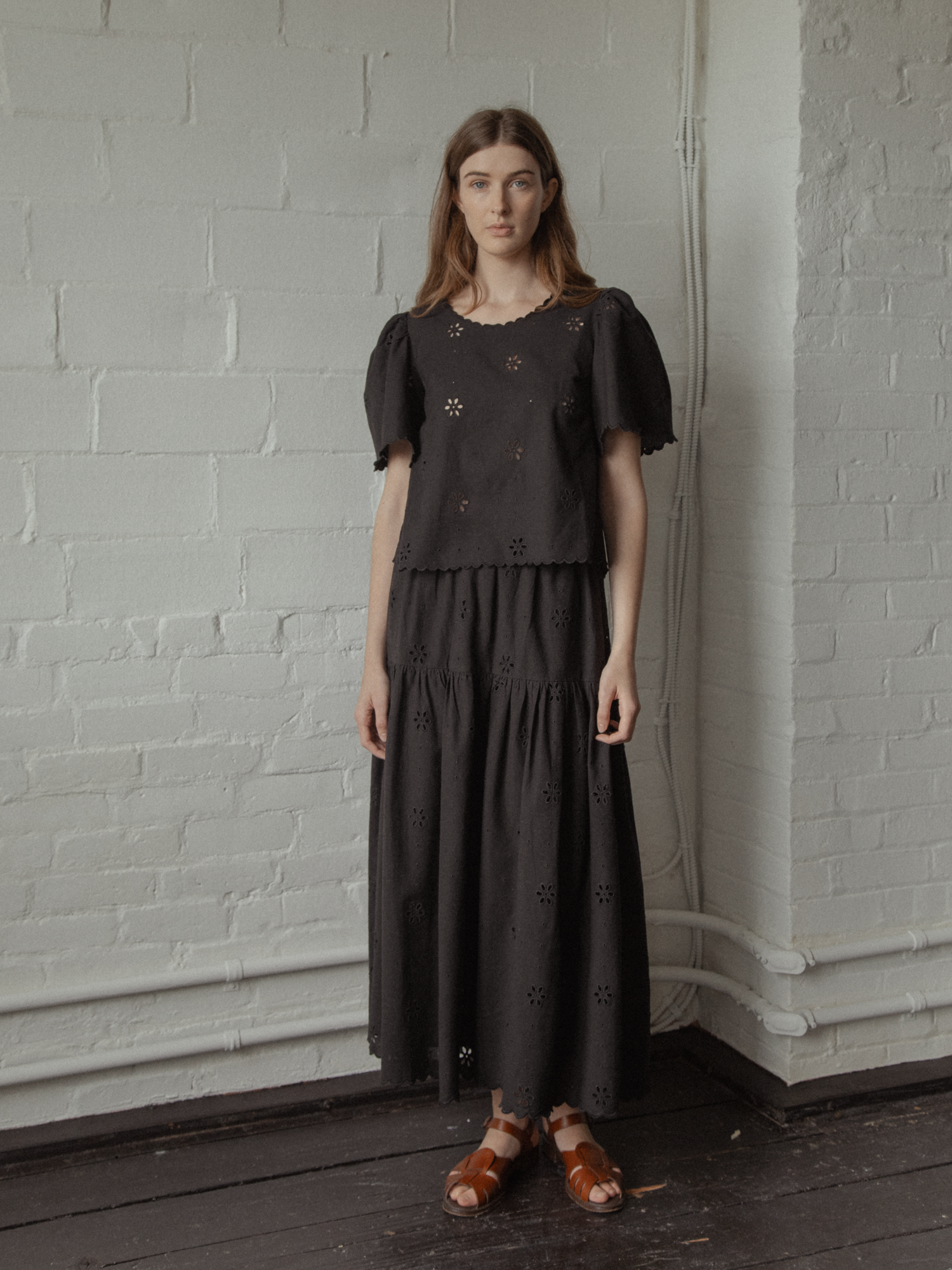 Model wearing the Stella Skirt in Noir by Gillian Stevens, full-length front view with matching broderie top