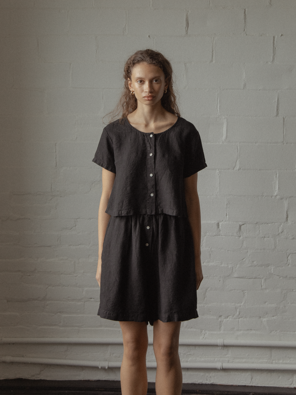 Model wearing the Wren Top in Noir by Gillian Stevens, styled with matching linen shorts, front view