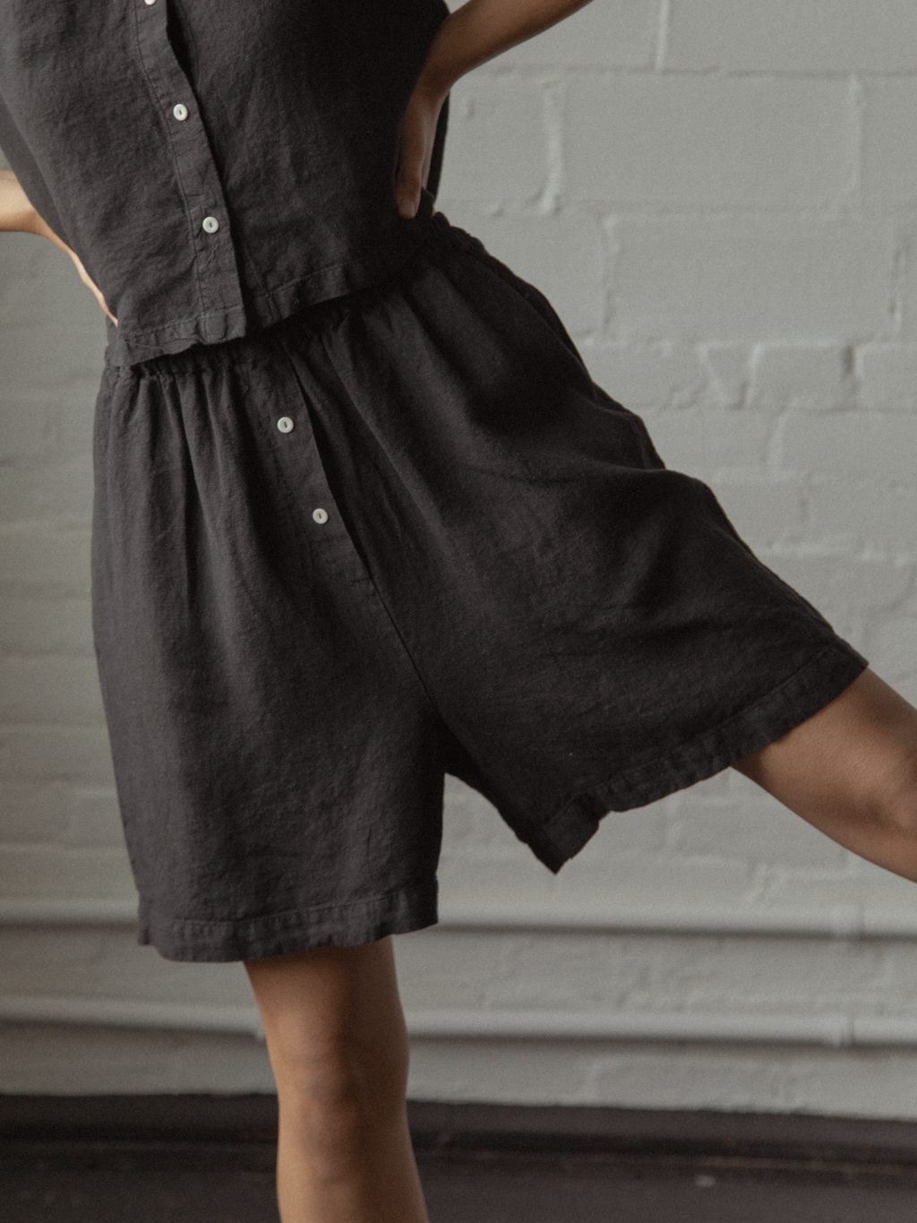 Close-up of model in the Sally Shorts in Noir by Gillian Stevens, showing elasticated waist and button detail