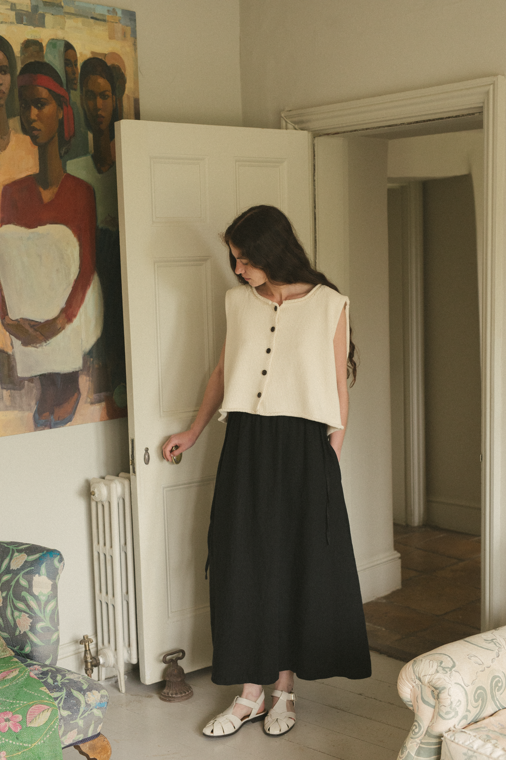 Model wearing the Frances Skirt in Noir by Gillian Stevens, full-length front view in styled interior