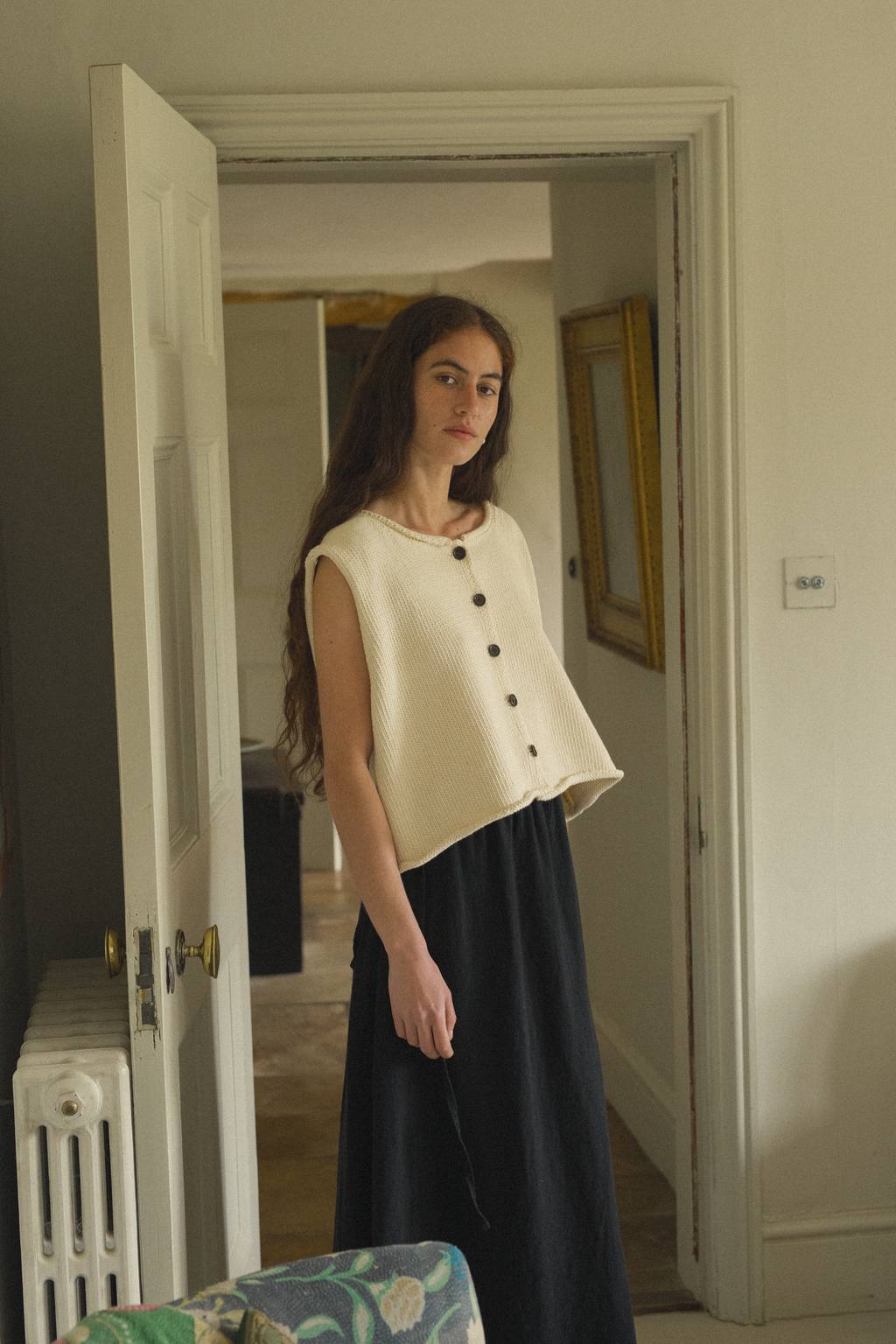 Model wearing the Lennon Vest in Ivory by Gillian Stevens, front view in a period interior setting