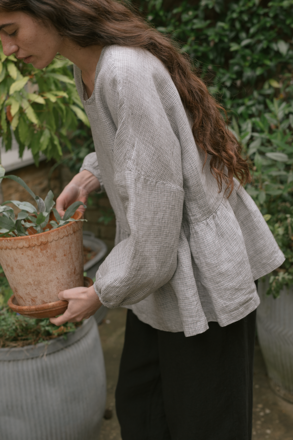 Model wearing the Darla Blouse in Dove Check by Gillian Stevens, side view showing peplum hem and balloon sleeve