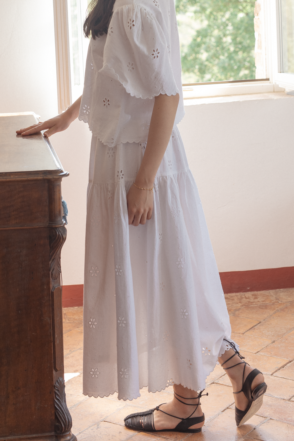 Model wearing the Stella Skirt in Salt by Gillian Stevens, side view showing tiered skirt and eyelet detail