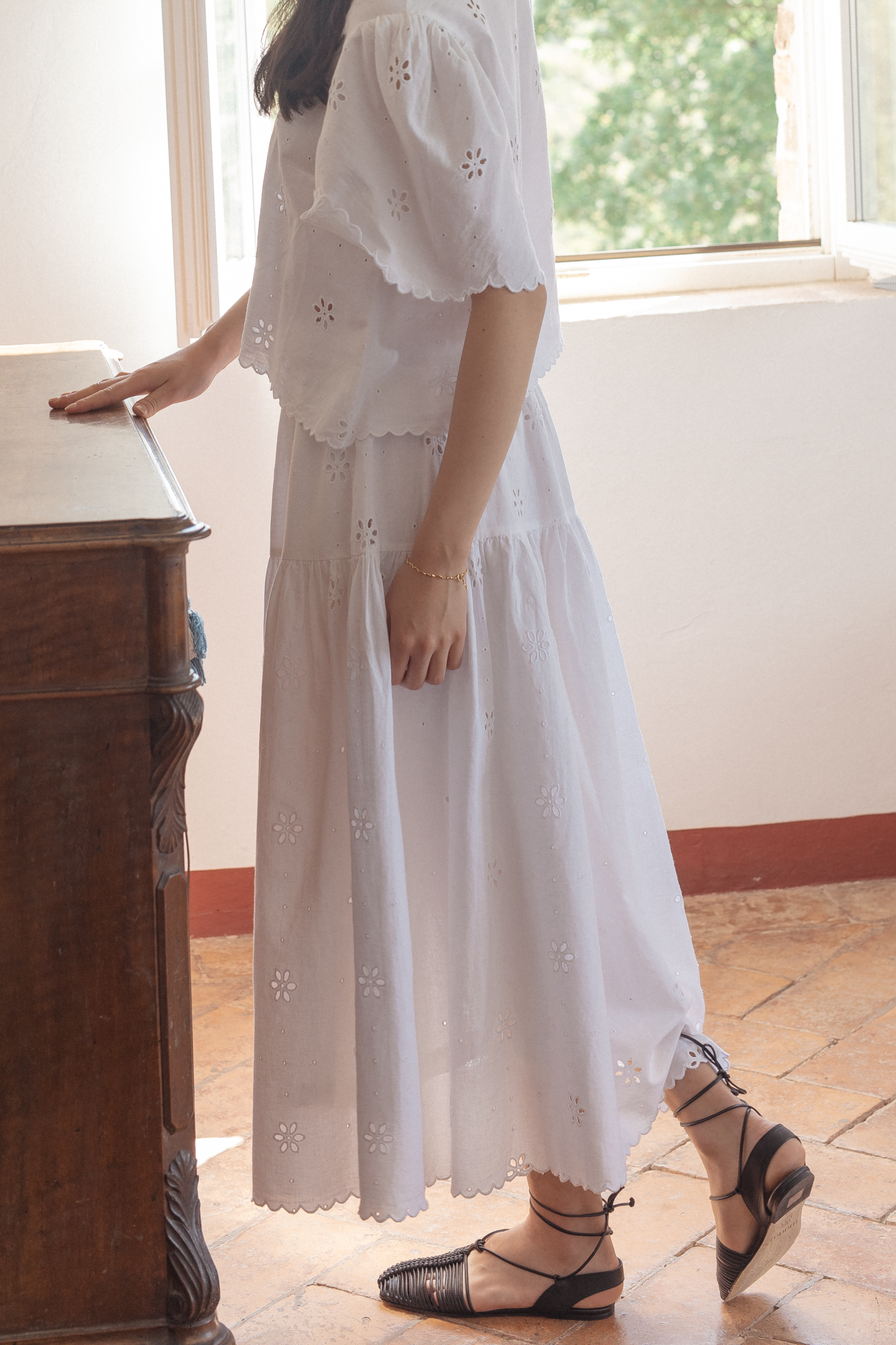 Model wearing the Stella Skirt in Salt by Gillian Stevens, side view showing tiered skirt and eyelet detail