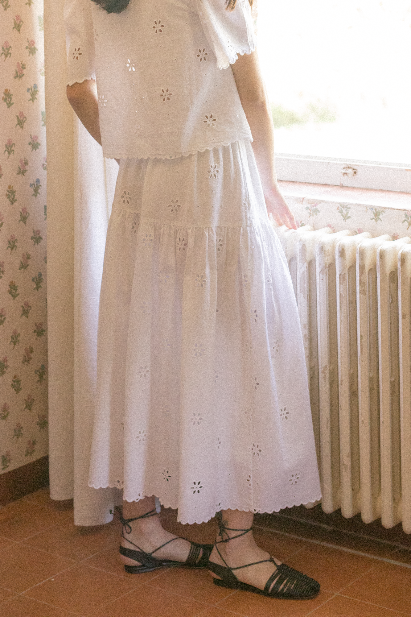 Model wearing the Stella Skirt in Salt by Gillian Stevens, showing tiered eyelet skirt with scalloped hem