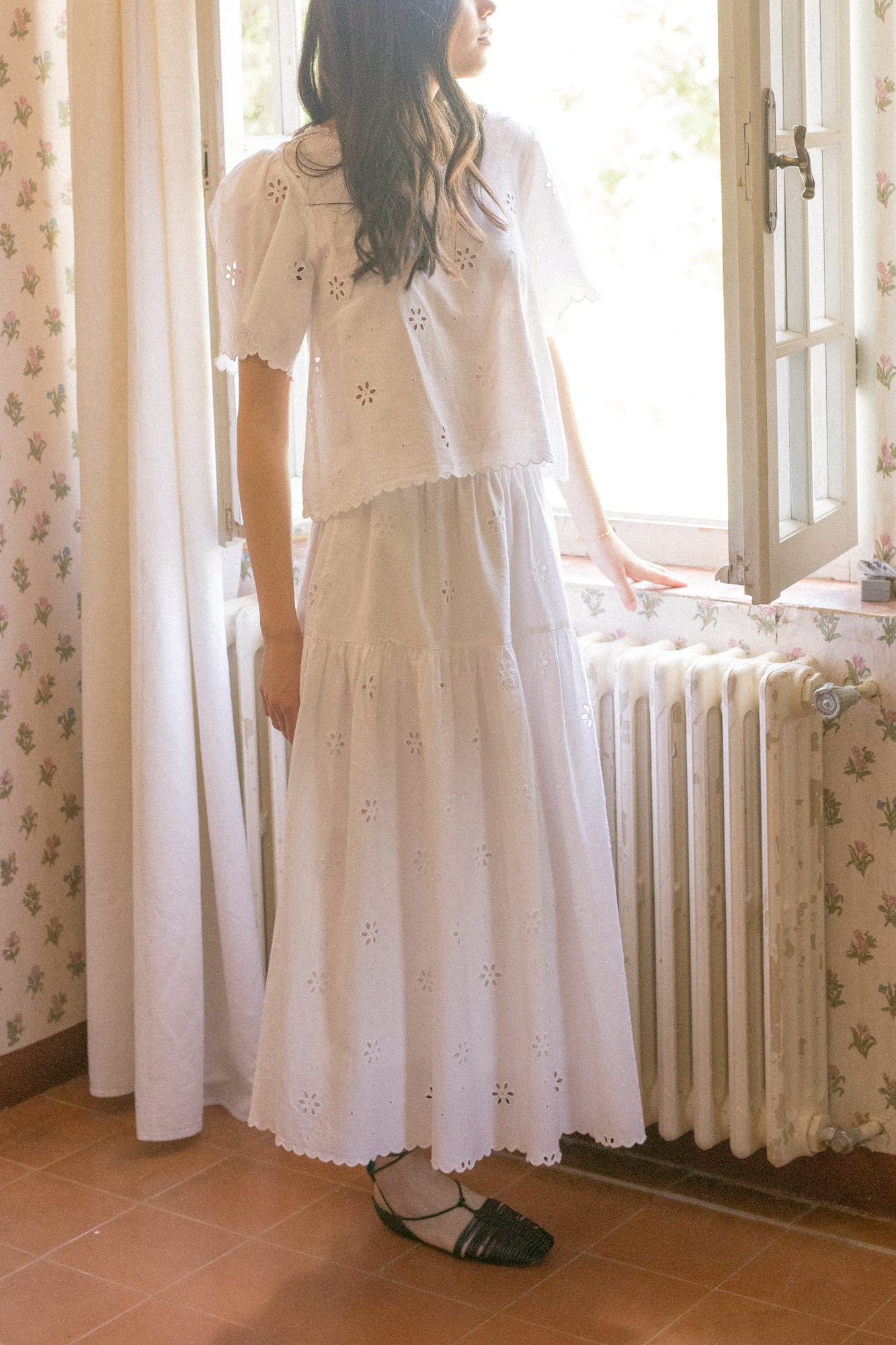 Model wearing the Stella Skirt in Salt by Gillian Stevens, side view styled with a matching eyelet top