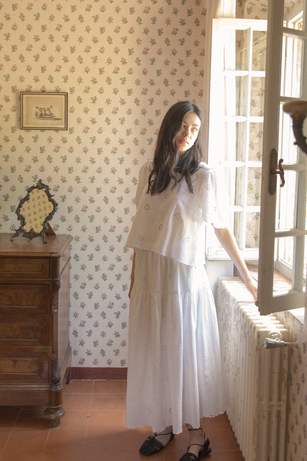 Model wearing the Stella Skirt in Salt by Gillian Stevens, side view styled with matching eyelet top