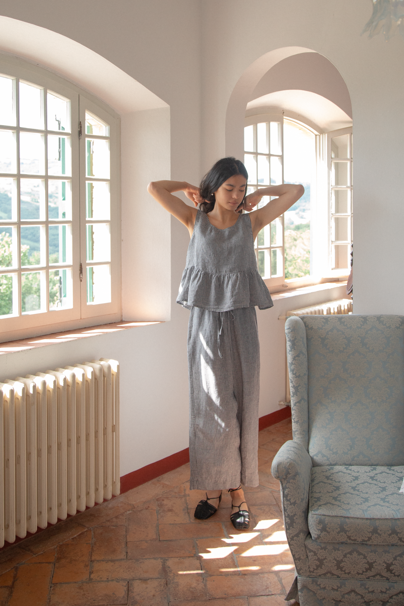 Model wearing the Olive Pant in Marine Gingham by Gillian Stevens, full-length front view in a sunlit room