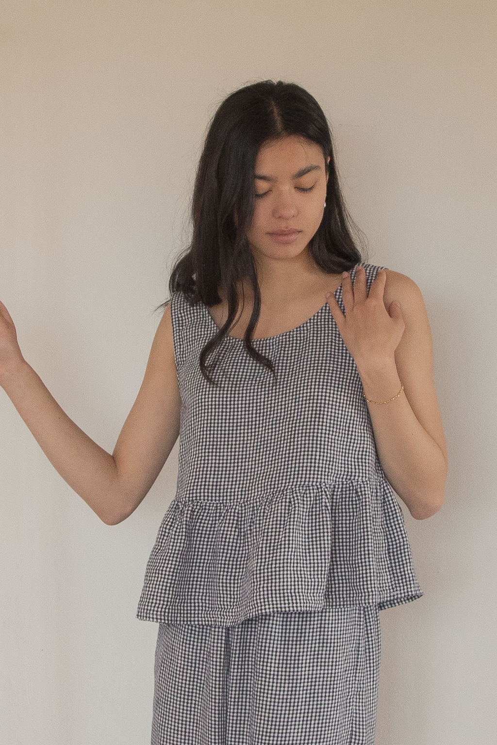 Model wearing the Marlowe Top in Marine Gingham by Gillian Stevens, front view showing peplum hem detail