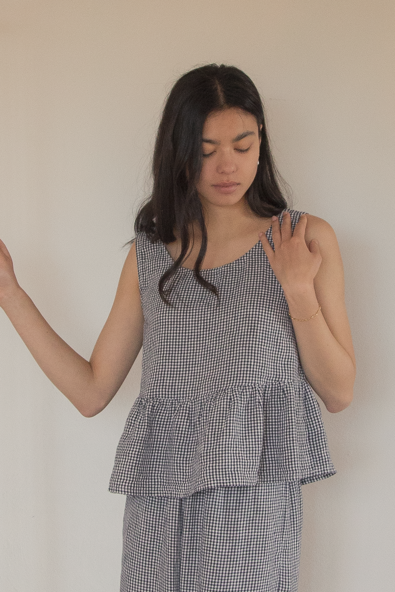 Model wearing the Marlowe Top in Marine Gingham by Gillian Stevens, front view showing peplum hem detail