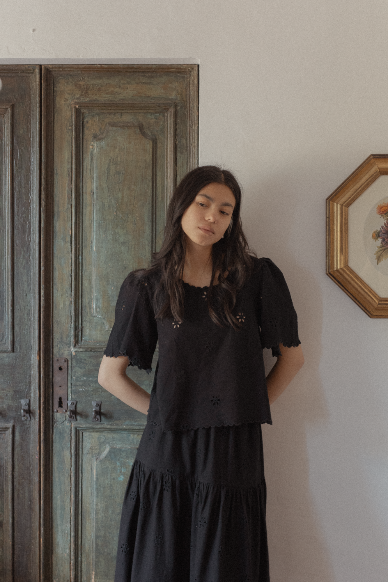 Model wearing the Stella Top in Noir by Gillian Stevens, front view showing eyelet detail and puff sleeves