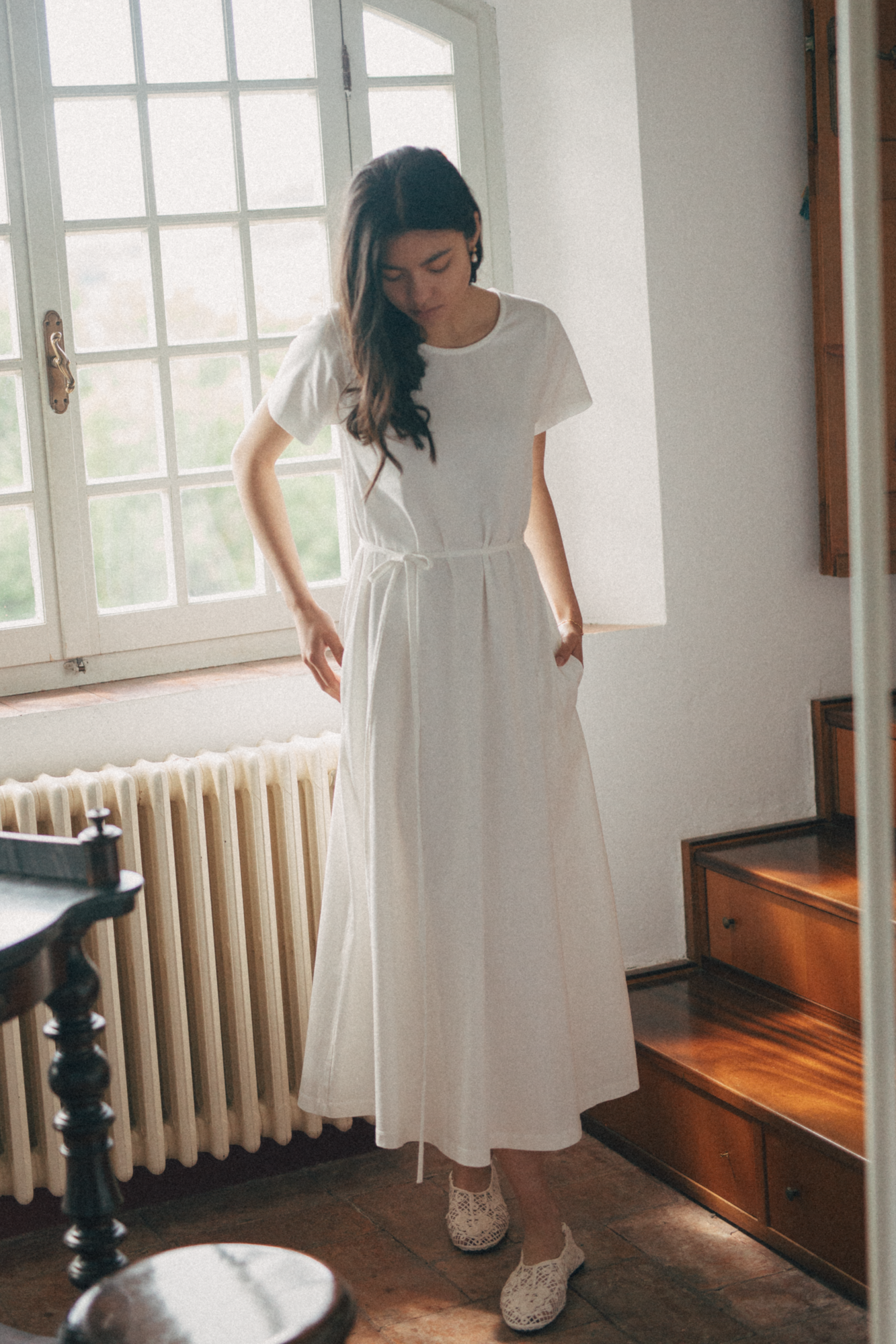 Model wearing the Palmer Dress in Salt by Gillian Stevens, front view showing drawstring waist and full midi skirt
