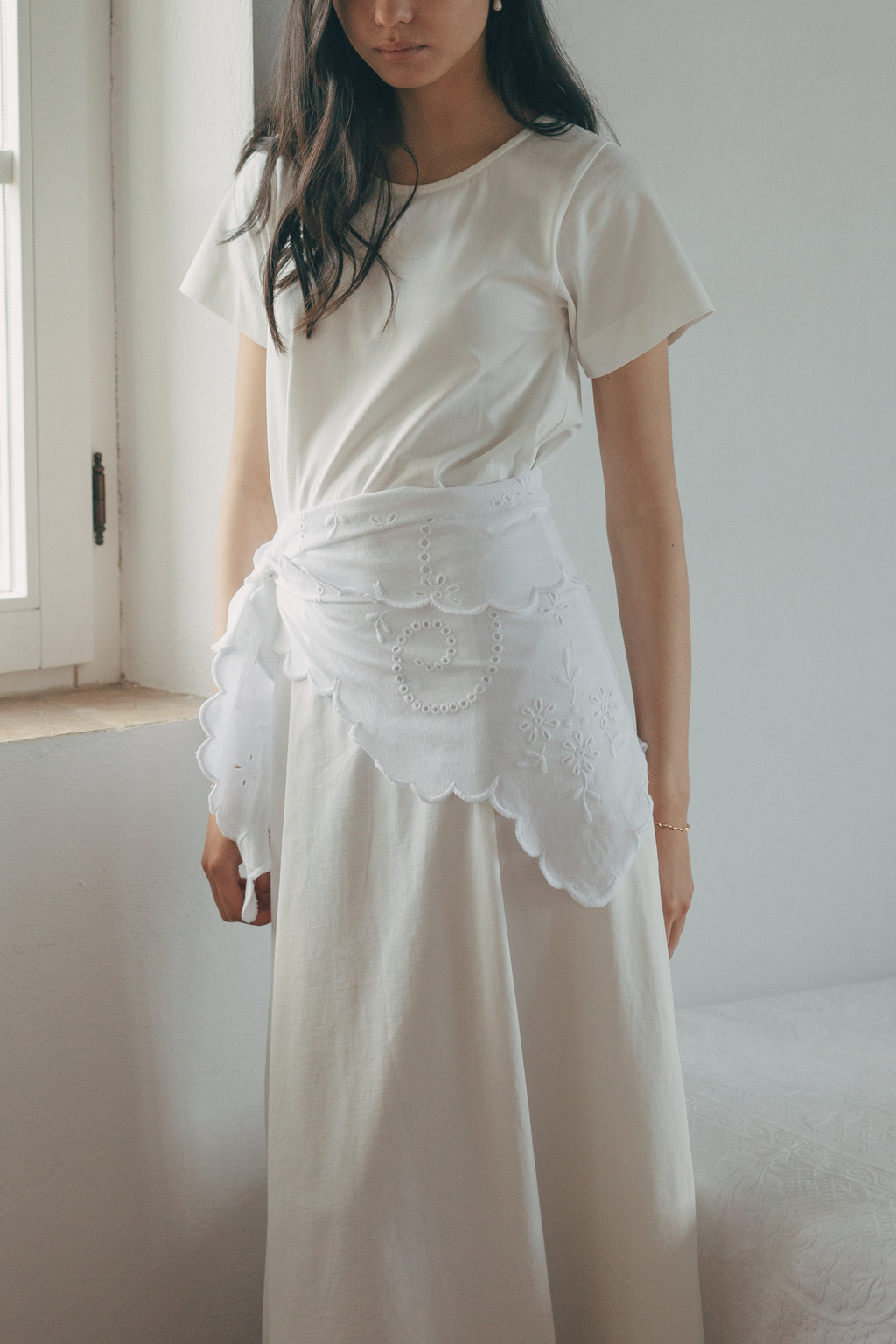 Model wearing the Matilde Scarf in Salt by Gillian Stevens, tied at the waist over a maxi skirt, showing broderie detail