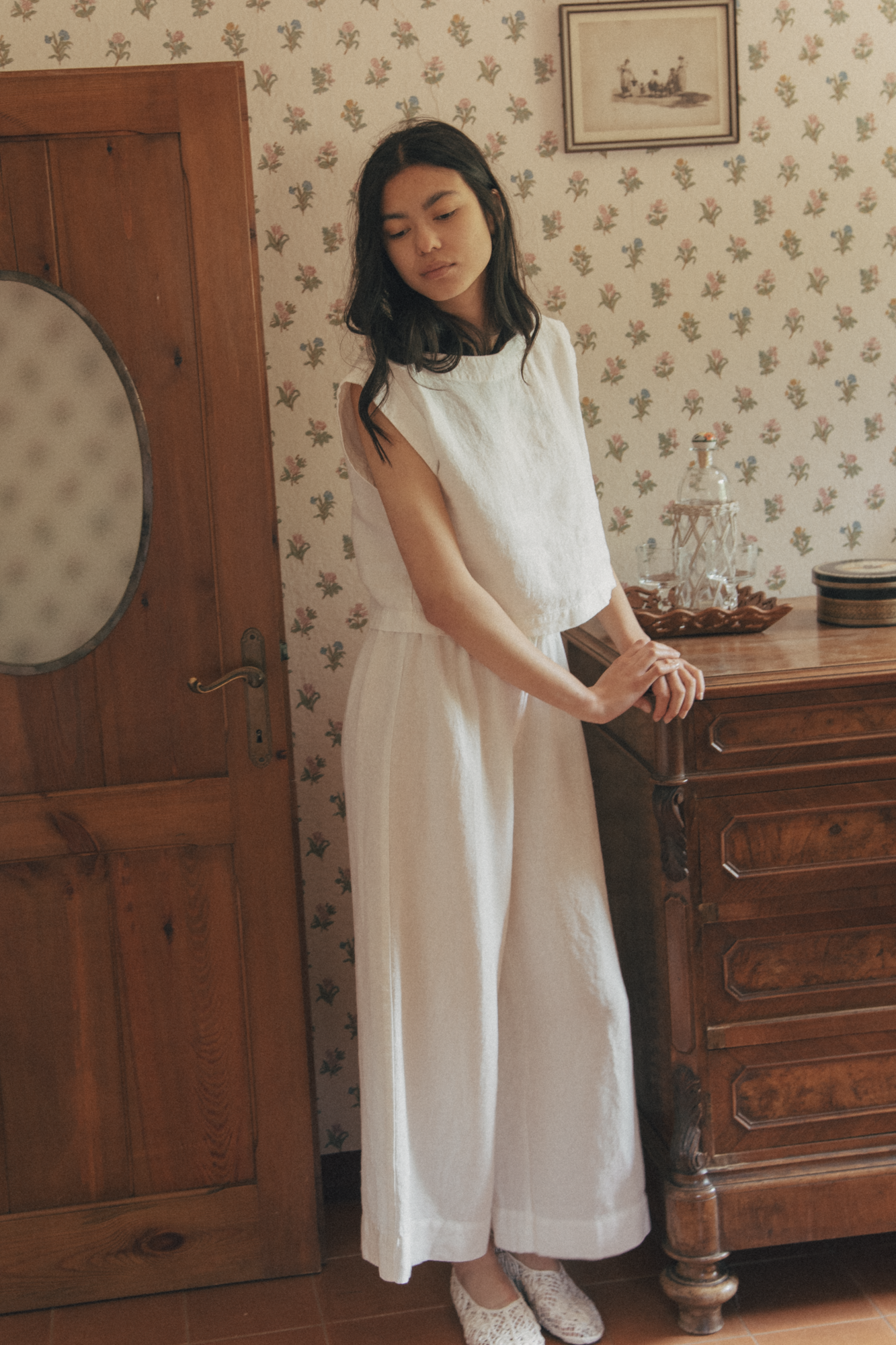 Model wearing the Valley Top in Salt by Gillian Stevens, styled as a dress in a vintage room setting
