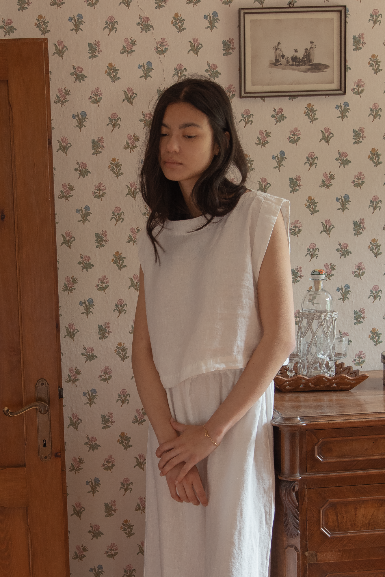 Model wearing the Valley Top in Salt by Gillian Stevens, front view in a vintage-styled room