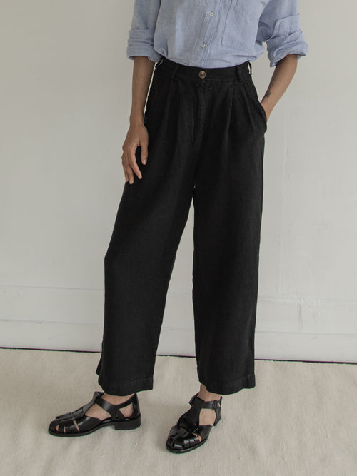 Model wearing the Andy Trouser in Noir by Gillian Stevens, front view showing pleat and pocket detail