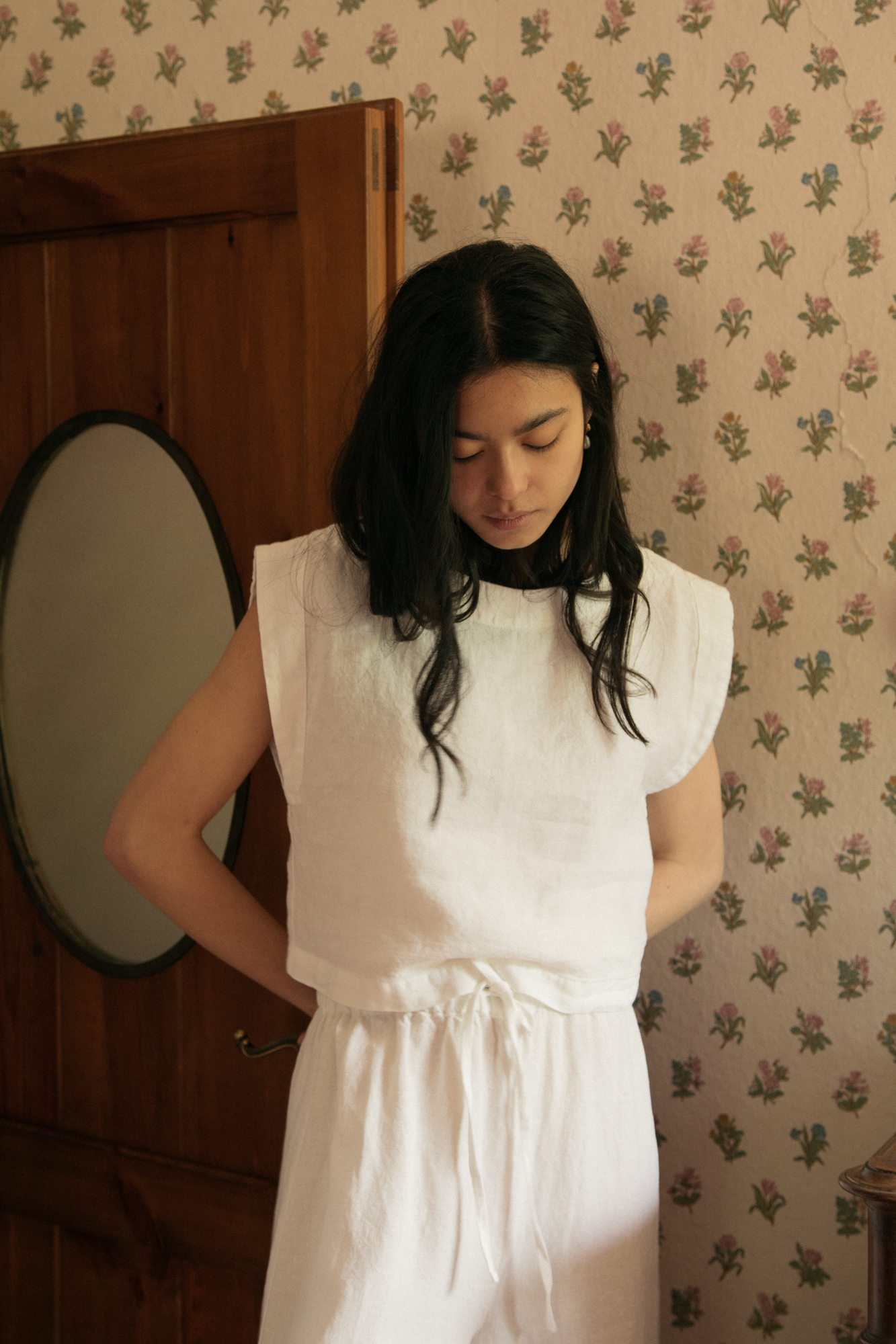 Model wearing the Valley Top in Salt by Gillian Stevens, front view styled with matching white drawstring pants