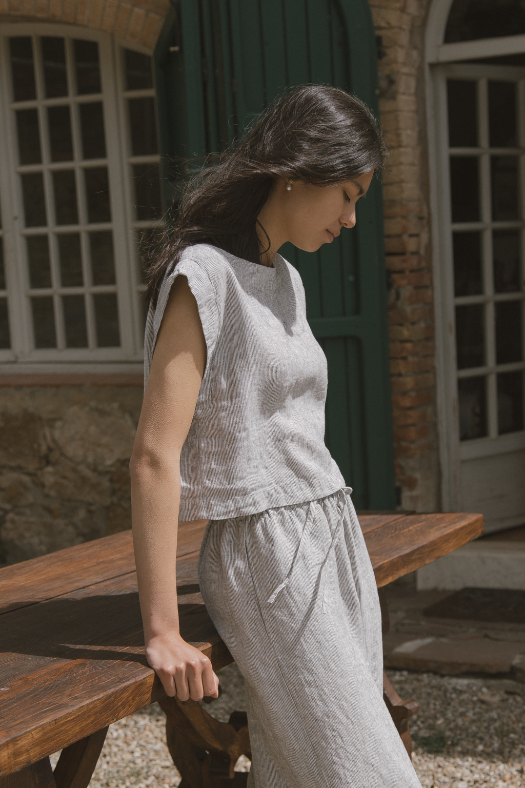 Model wearing the Valley Top in Charcoal Stripe by Gillian Stevens, side view outdoors