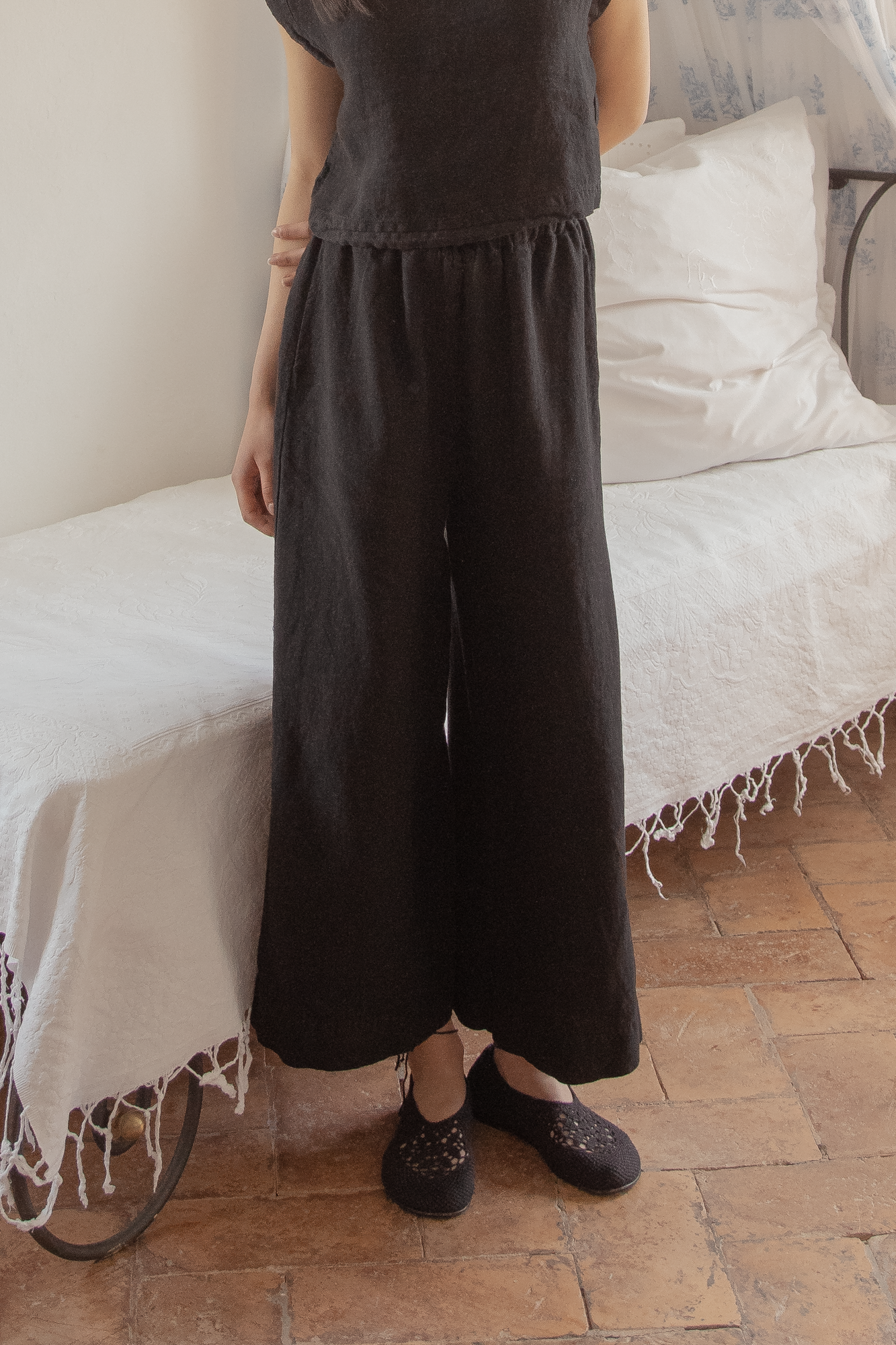 Model wearing the Ines Pant in Noir by Gillian Stevens, front view showing wide leg and elasticated waist